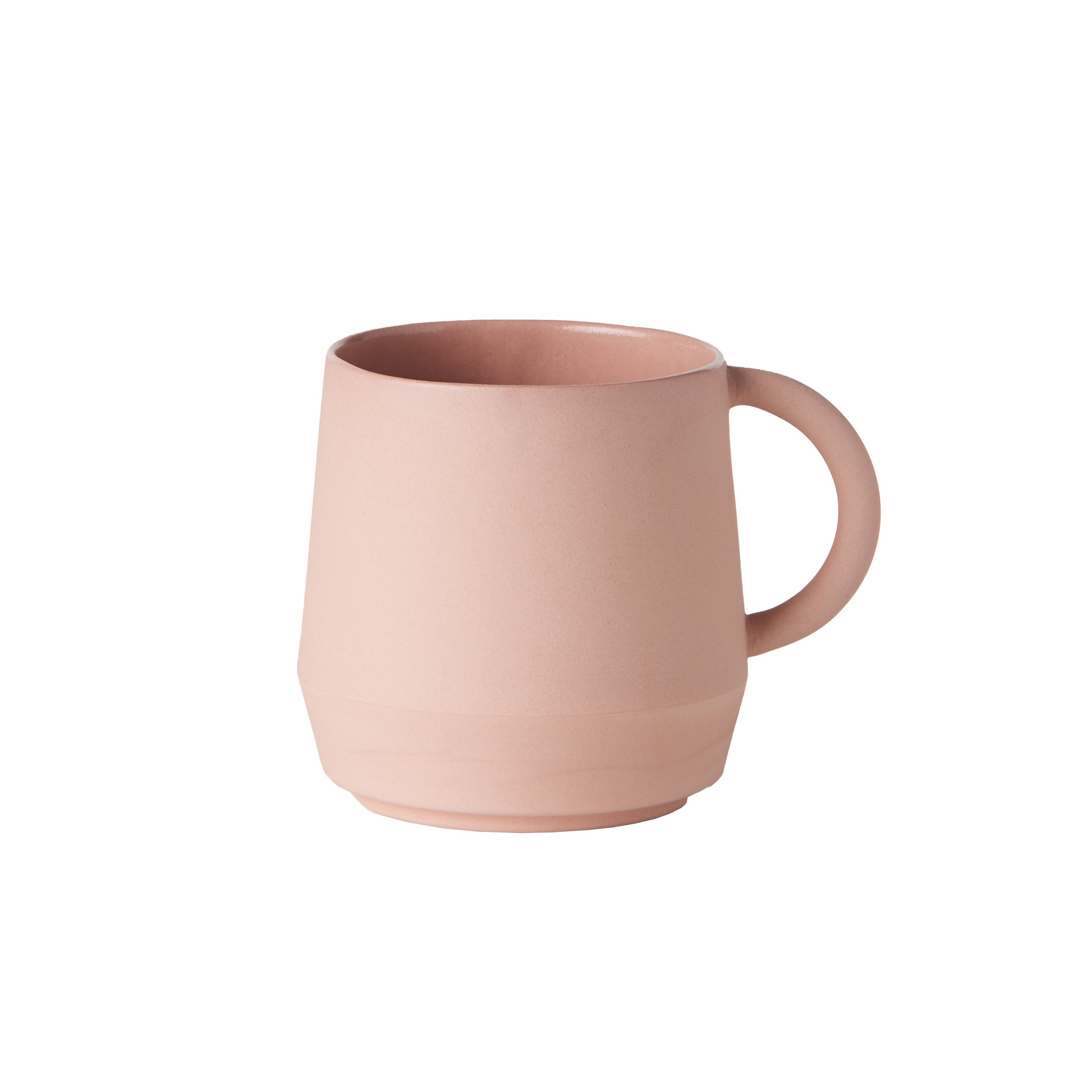 The Unison Cup by Schneid is a pink ceramic cup with a modern, tapered design and round handle. Handmade in Germany, it stands out against a white background, embodying minimalist aesthetics and making it ideal for any versatile ceramic tableware collection.