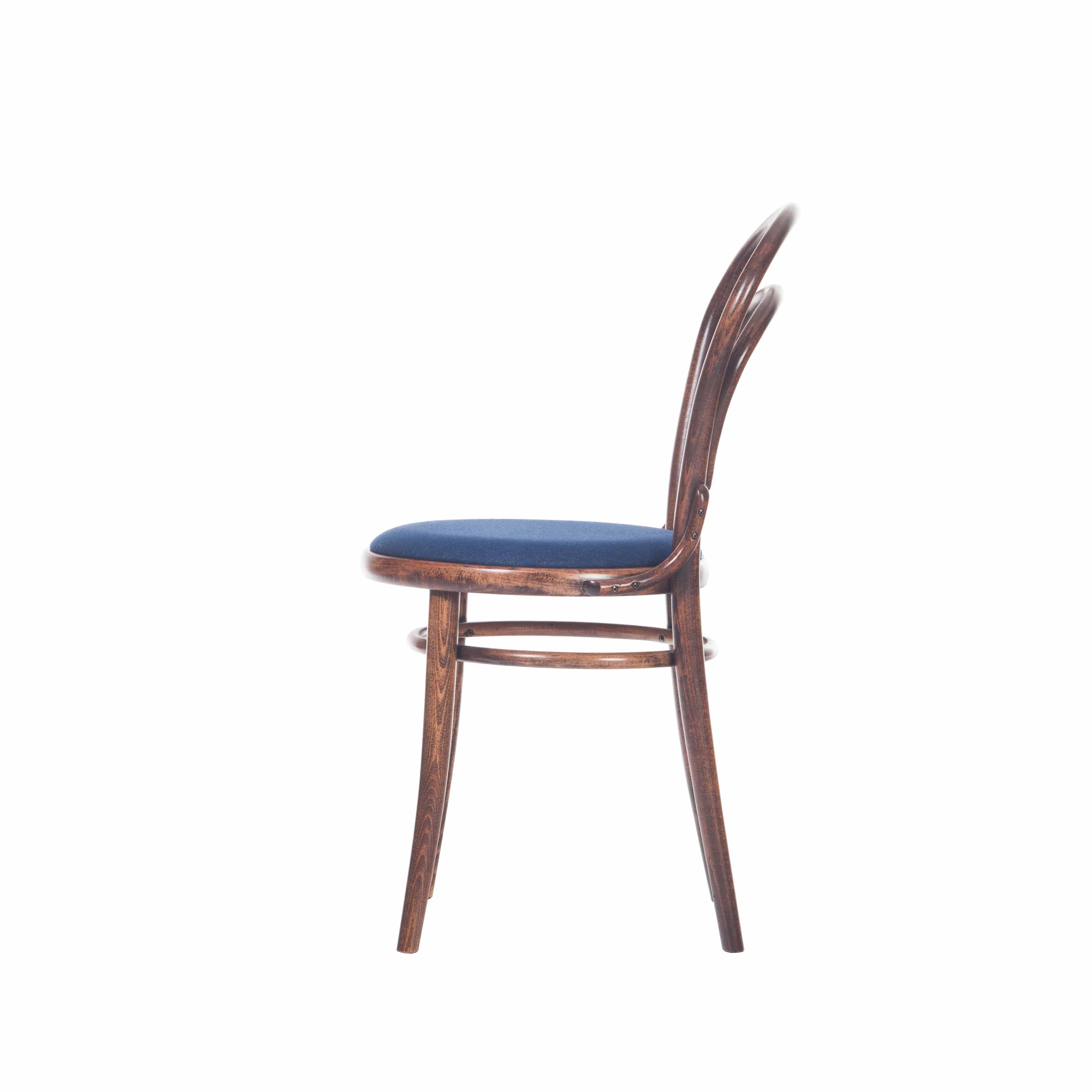 A side view of TONs Chair 14 - Cane showcases a classic dining chair with a curved backrest and round blue cushioned seat. Bentwood legs evoke timeless elegance, reminiscent of a traditional café chair. The plain white background highlights its refined design.