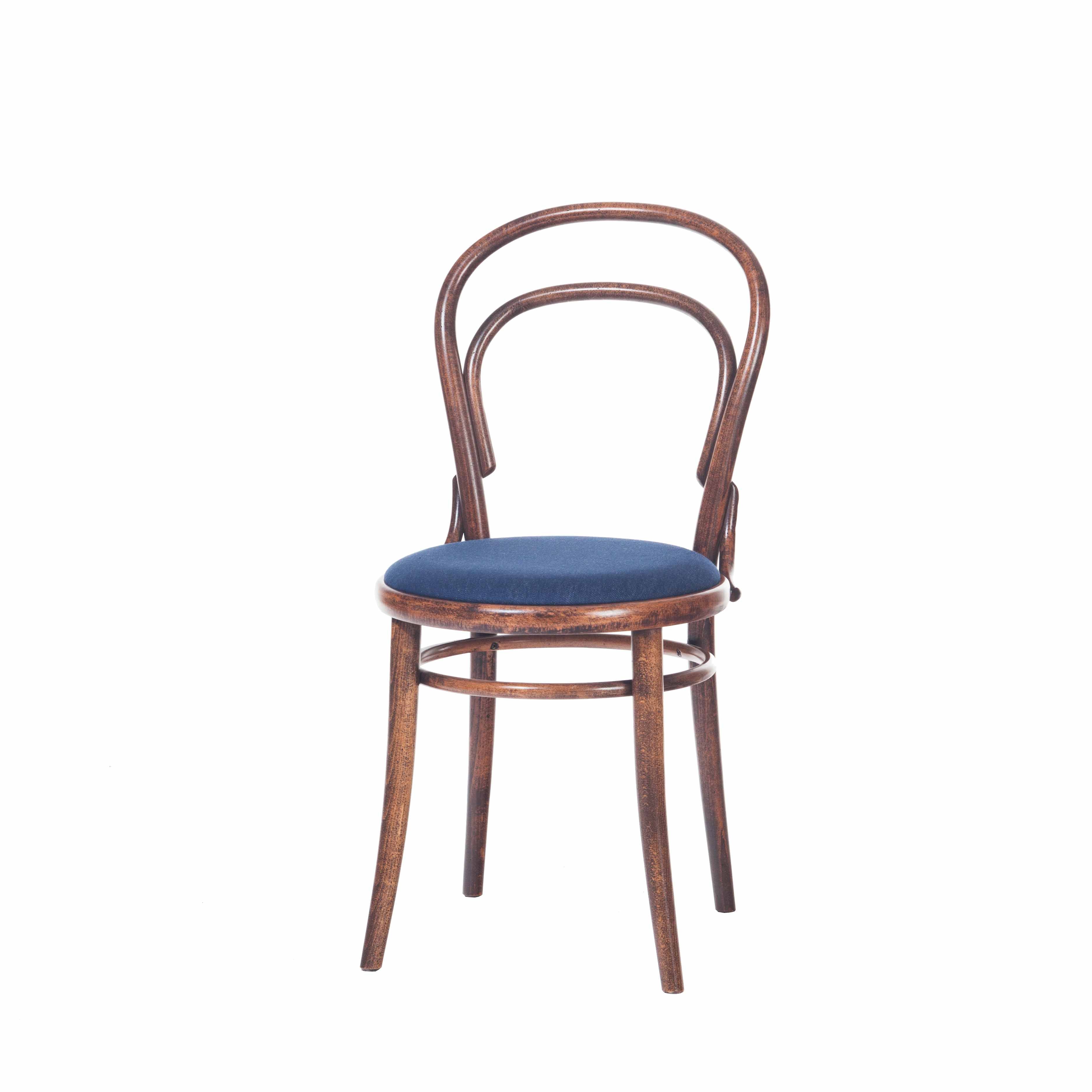 The Chair 14 - Cane by TON is a wooden café chair with a round seat upholstered in dark blue fabric. It features a curved backrest for an elegant, classic look and stands on four legs with a slightly glossy finish against a plain white background.