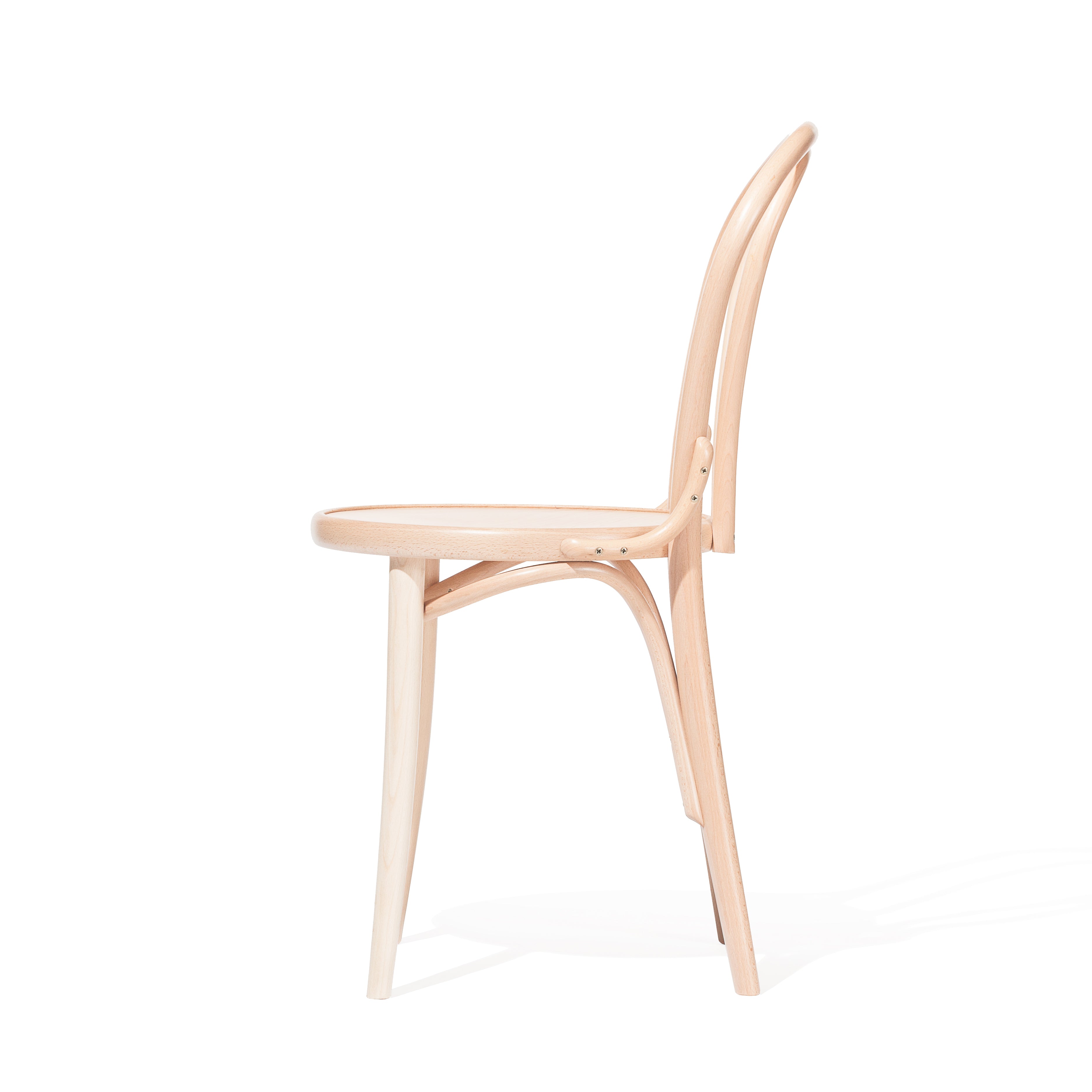 A side view of the sleek, contemporary Chair 18 - Cane by TON, showcasing its minimalist design with a curved backrest and no armrests. The chair features elegantly bent wood elements for support and a light beech wood finish.
