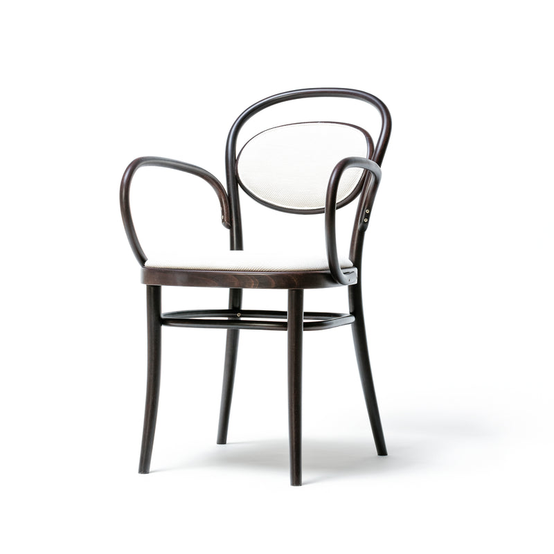 The Armchair 20 by TON is a wooden chair with a dark beech finish, featuring a rounded backrest. It includes curved armrests, a circular light-colored cushioned panel on the backrest, and is complemented by a plain seat and straight legs against a white background.