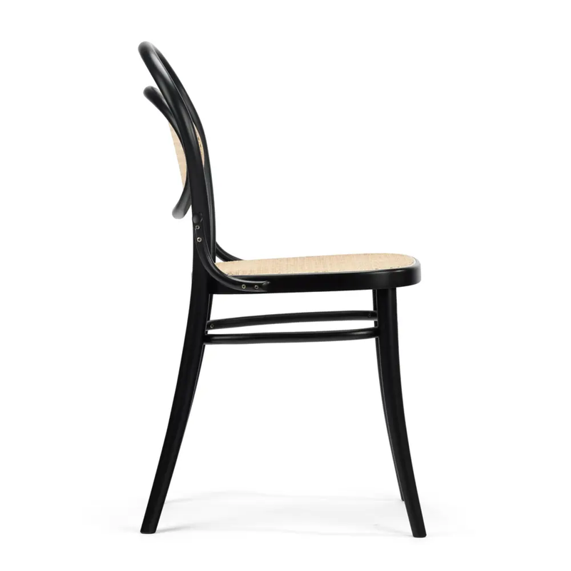 A side view of the black wooden Chair 20 Cane- Sale from TON, featuring a curved backrest and cane seating. Its sleek design expertly blends modern and classic styles, with a minimalist aesthetic that showcases refined craftsmanship.