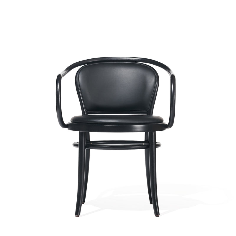 The Armchair 33 by TON features a sleek, black upholstered design with a curved backrest and armrests. It has slightly angled legs and a round seat, embodying modern minimalism against a white backdrop.