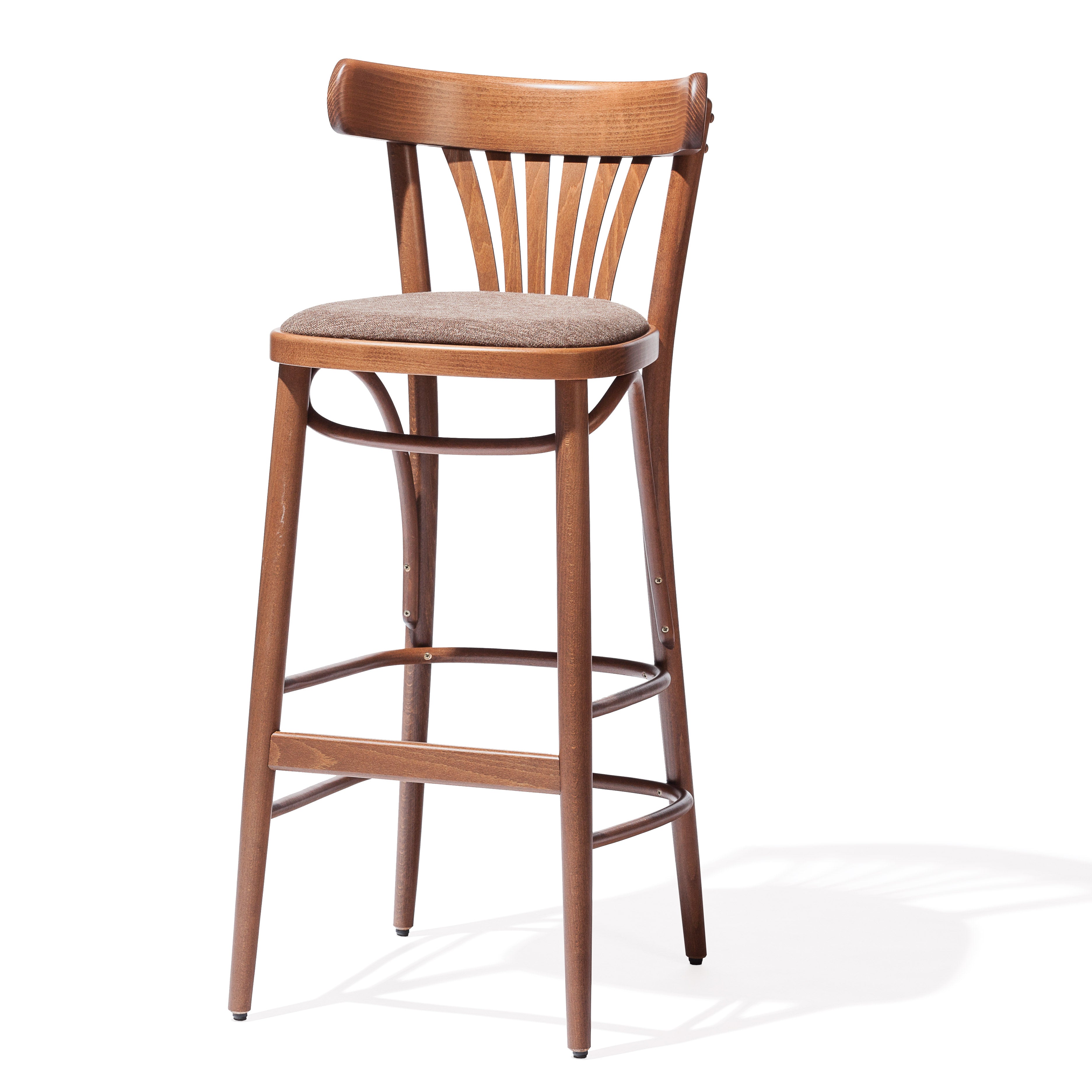 The Barstool 56 by TON is a wooden stool with a cushioned seat and curved backrest featuring vertical slats. Crafted from rich brown plywood, it has four legs with horizontal supports for sturdiness and a cushion upholstered in neutral fabric for an elegant finish.