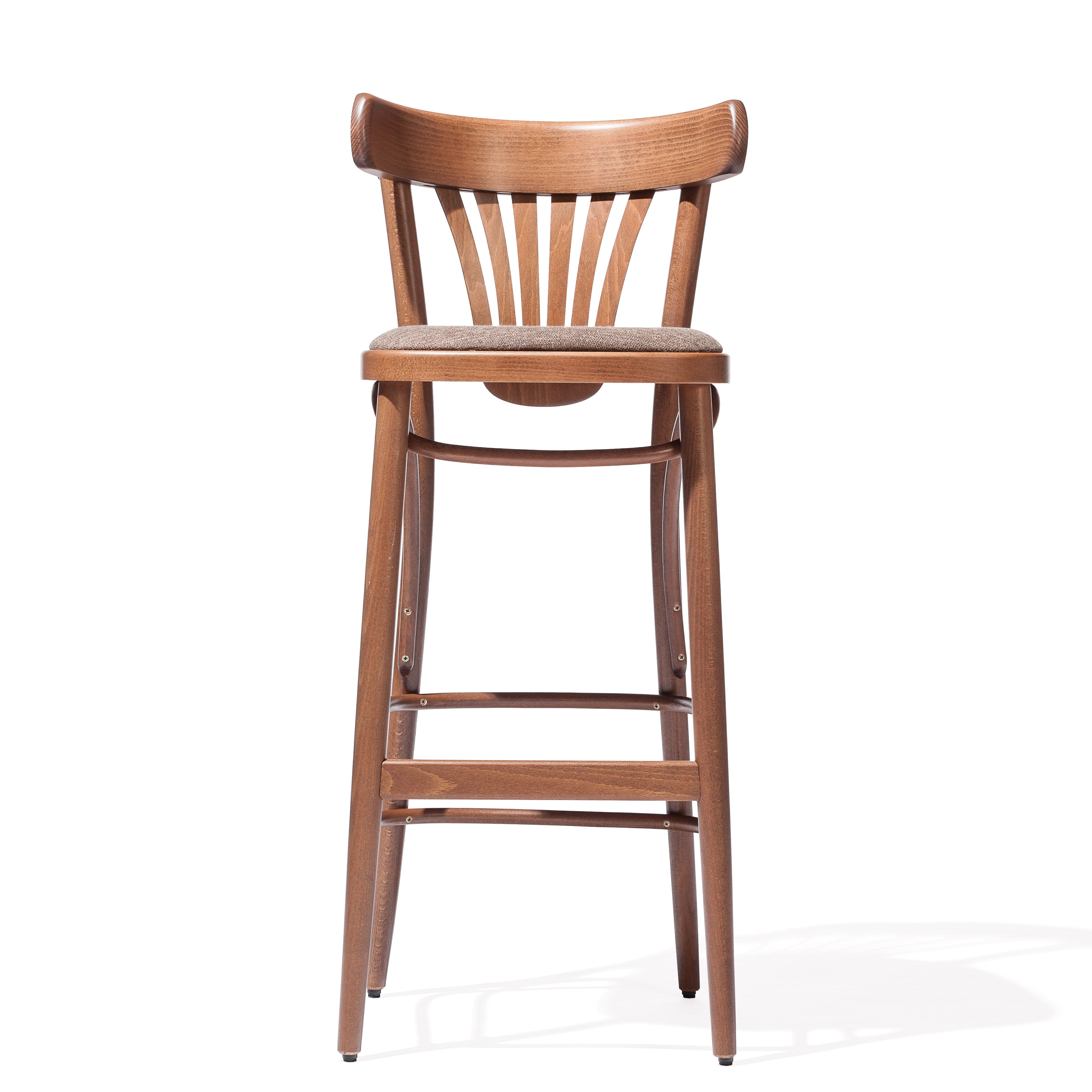 The Barstool 56 by TON boasts a curved backrest with vertical slats, a cushioned seat, and a plywood fan design. Its four legs are connected by horizontal support bars, all in a warm medium-brown wood finish.
