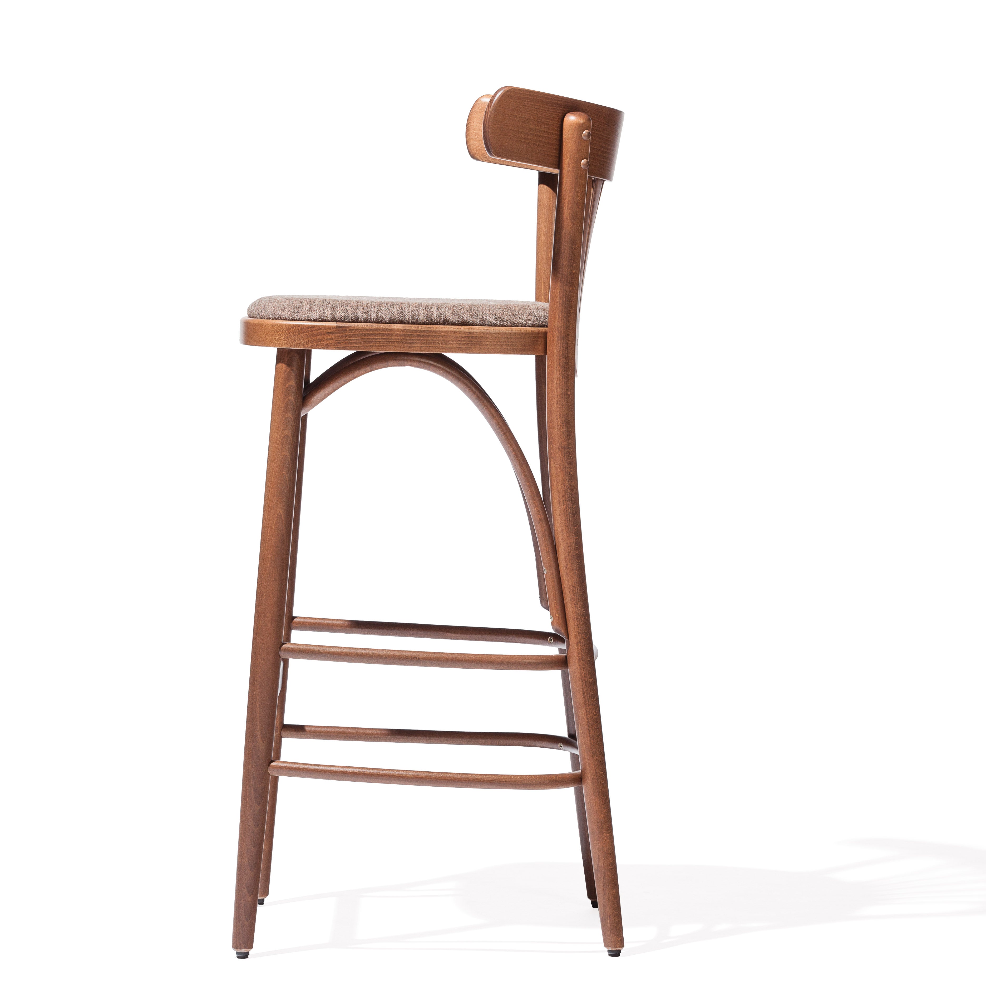The side view of the Barstool 56 by TON highlights a wooden frame with a cushioned seat, curved backrest, footrests, and smooth polished finish displaying expert upholstery.