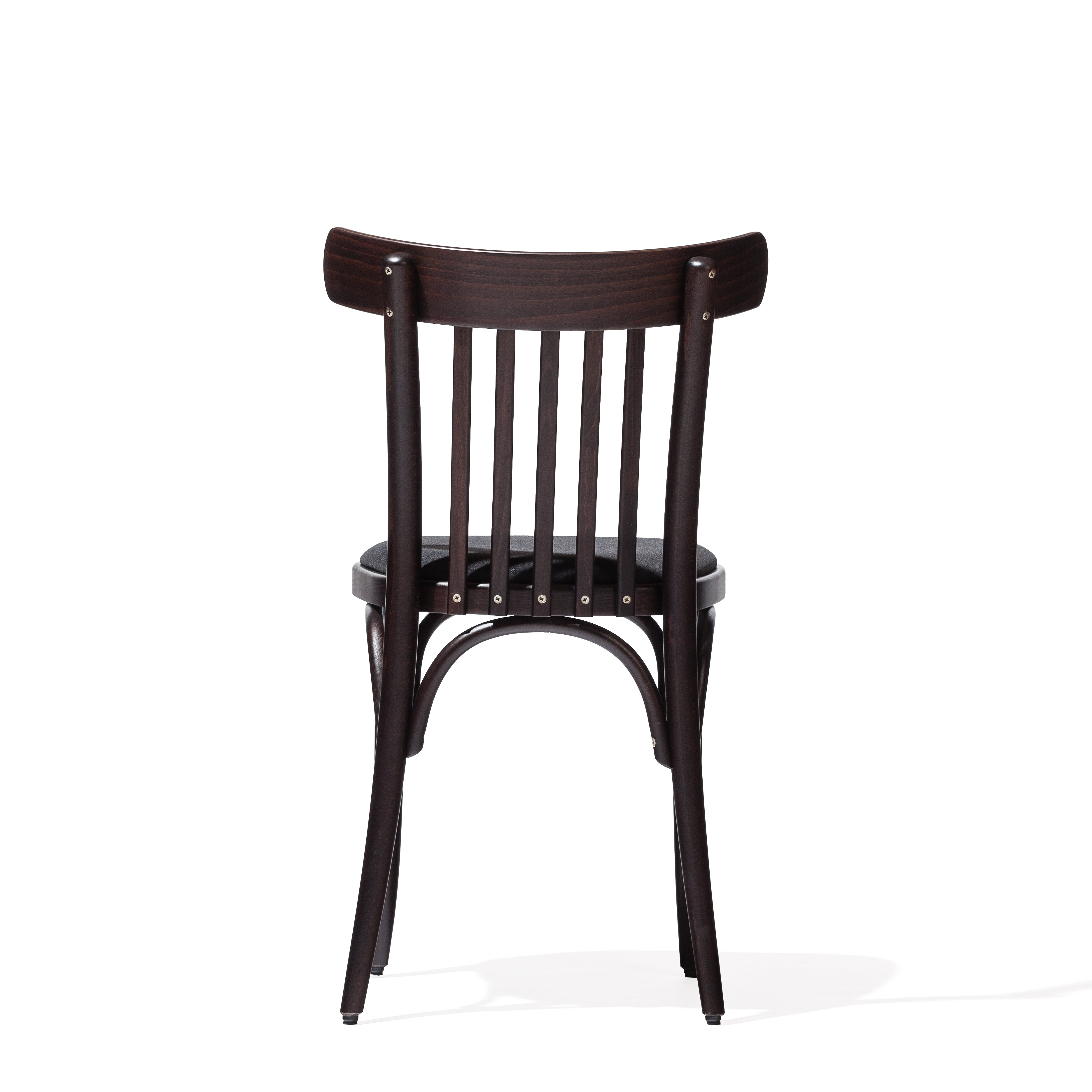 Chair 763 by TON is a dark-finished wooden chair reminiscent of the classic TON A, showcasing a slatted backrest and gently curved legs. Ideal for modern interiors, it boasts a simple, timeless design with a shadowed floor beneath it.