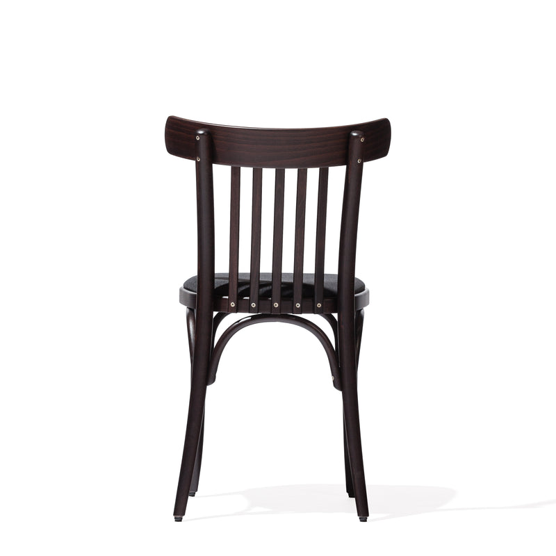 Chair 763 by TON is a dark-finished wooden chair reminiscent of the classic TON A, showcasing a slatted backrest and gently curved legs. Ideal for modern interiors, it boasts a simple, timeless design with a shadowed floor beneath it.