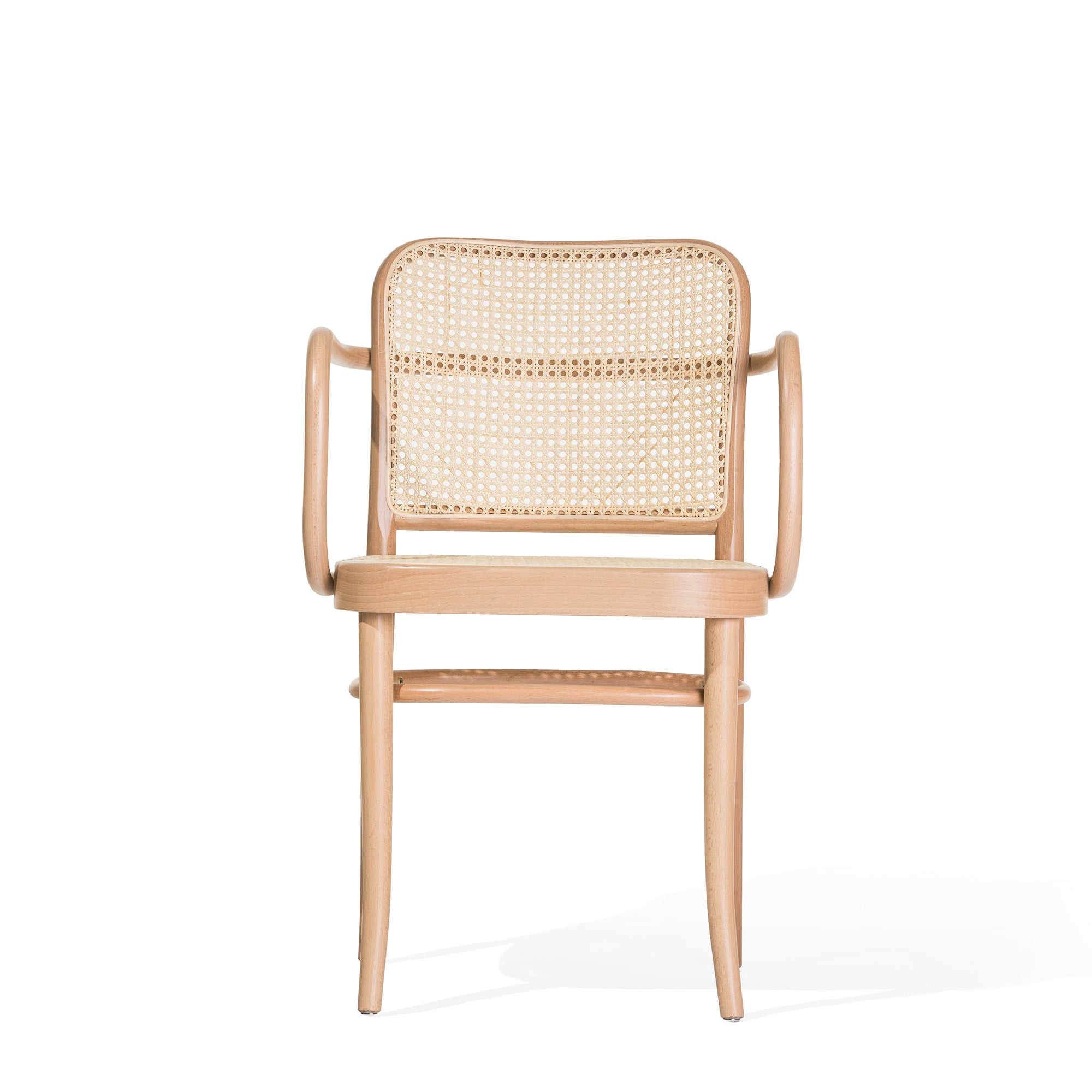 The Armchair 811 by TON is a wooden chair with a woven cane backrest and seat, inspired by Art Nouveau elegance. It features curved armrests and sturdy legs with a light wood finish, capturing the simple yet sophisticated style of Josef Hoffmann design.