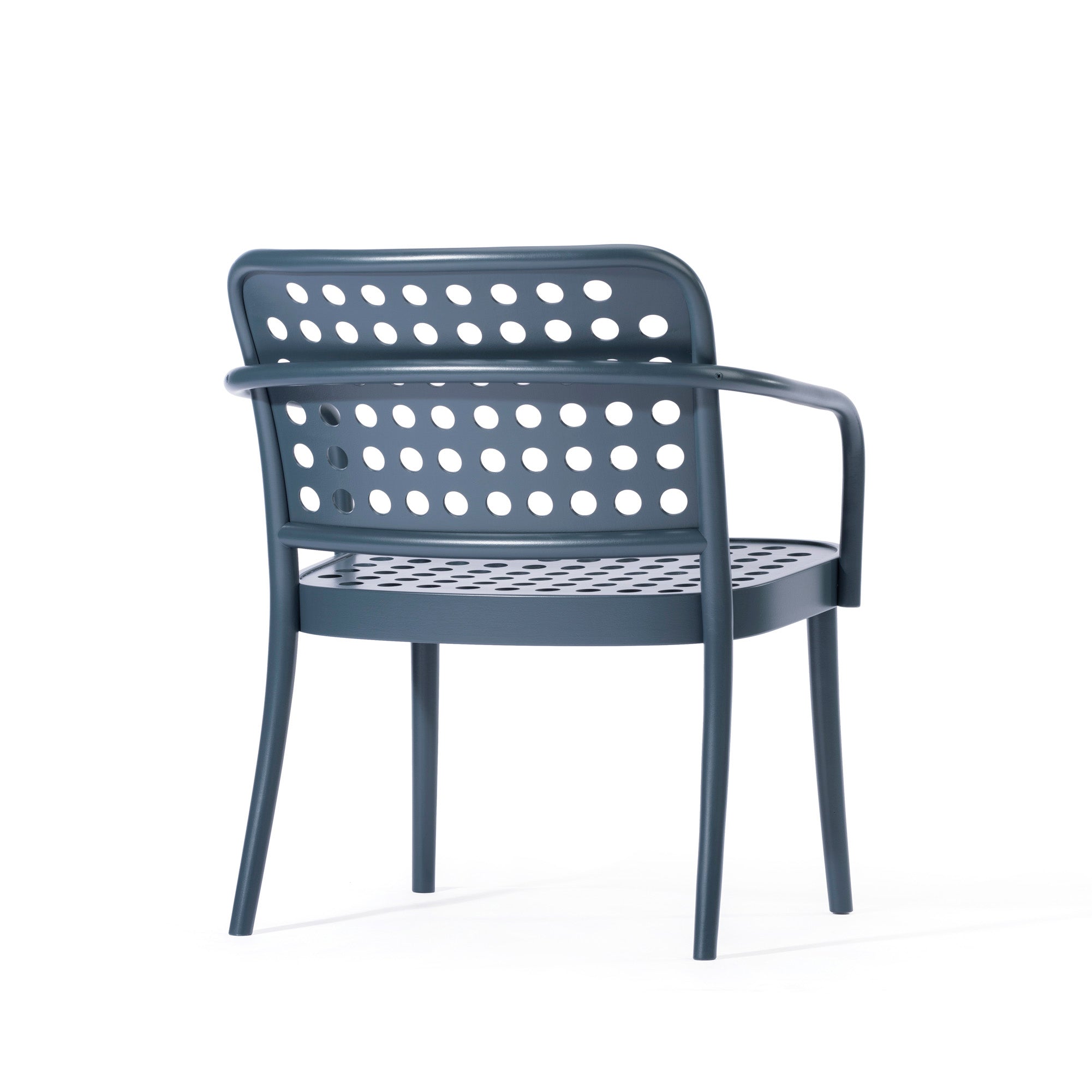 The Lounge Armchair 822 by TON features a modern blue design with a perforated backrest and seat, circular cut-out patterns, sleek armrests and legs against white. Inspired by Scandinavian minimalism, its style echoes the refined aesthetic of Claesson Koivisto Rune.