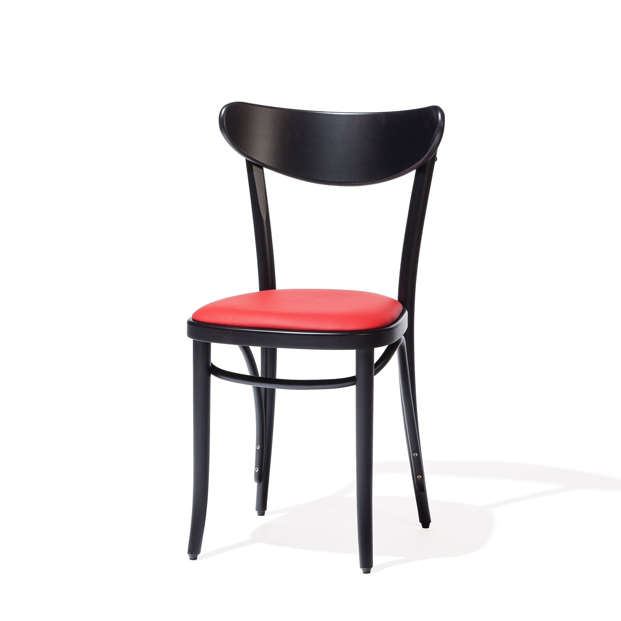 The Chair Banana by TON is a black bentwood chair featuring a curved plywood backrest and a red upholstered seat, showcasing simple, elegant lines against a white background.