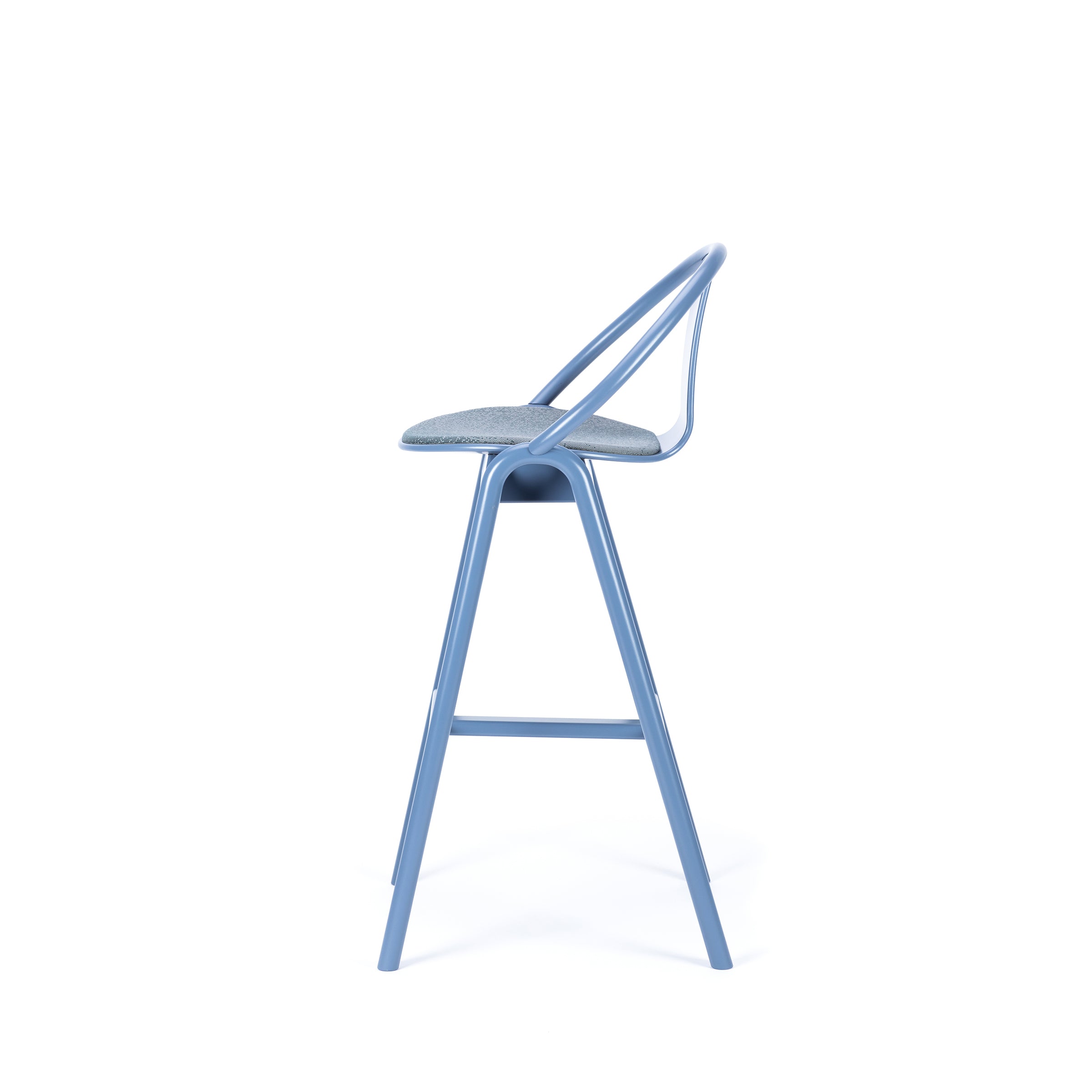 Side view of the Barstool Again Upholstered by TON, featuring a minimalist blue design with a sleek metal frame and curved backrest. The cushioned seat adds comfort and contemporary elegance reminiscent of handcrafted furniture. Set against a white background.