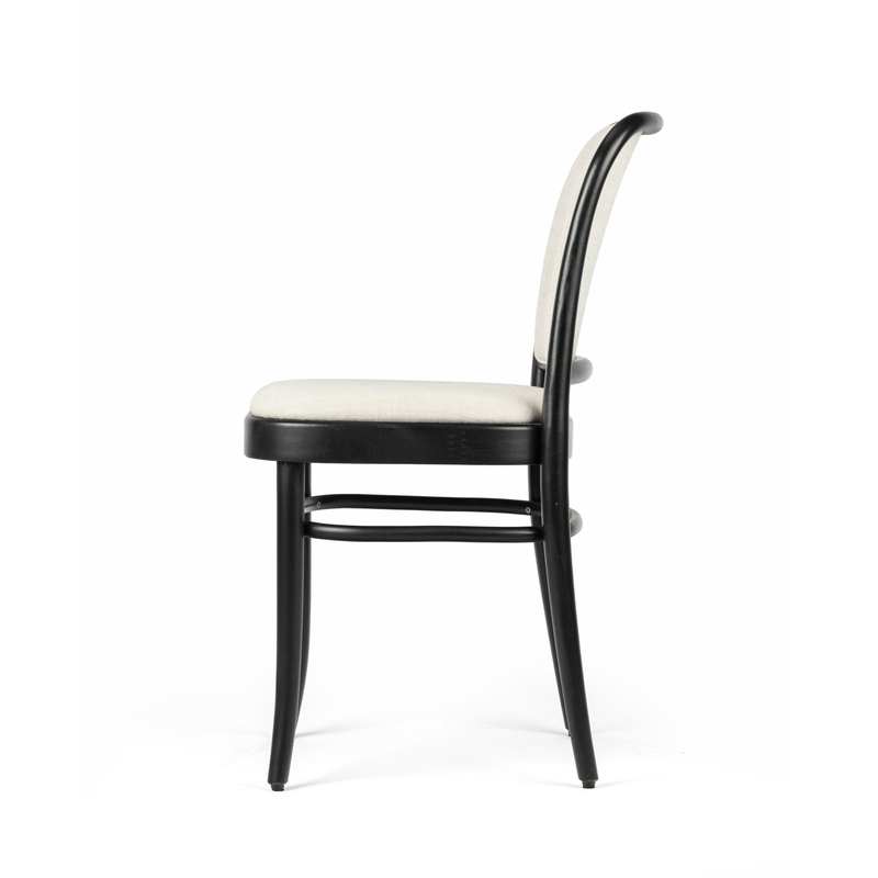 The Chair 811 - Upholstered by TON features a modern, minimalist design with a black frame and four curved legs. Its light grey cushioned seat and backrest echo Josef Hoffmanns style, while a simple crossbar underneath provides additional support.