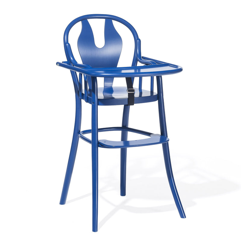 The Childrens Chair Petit 114 by TON is a blue high chair with a modern, sleek design featuring a rounded backrest and integrated safety belt. It offers an elevated seat and tray for feeding, enhanced by a minimalist metallic finish.