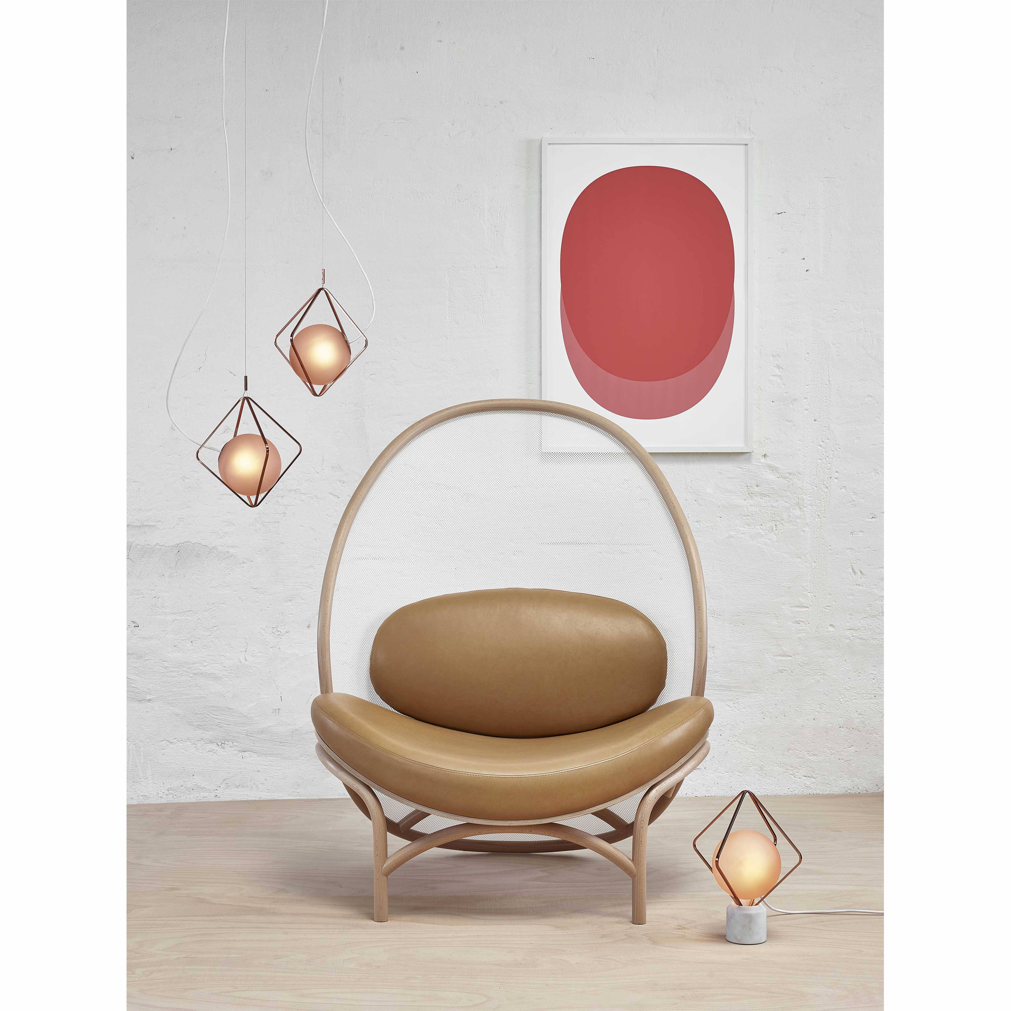 A modern interior features a TON Lounge Chair Chips - Sale with a manually-bent wooden frame and oval leather seat. To the left, three geometric pendant lights hang, and a red abstract art piece on the wall adds a contemporary touch.