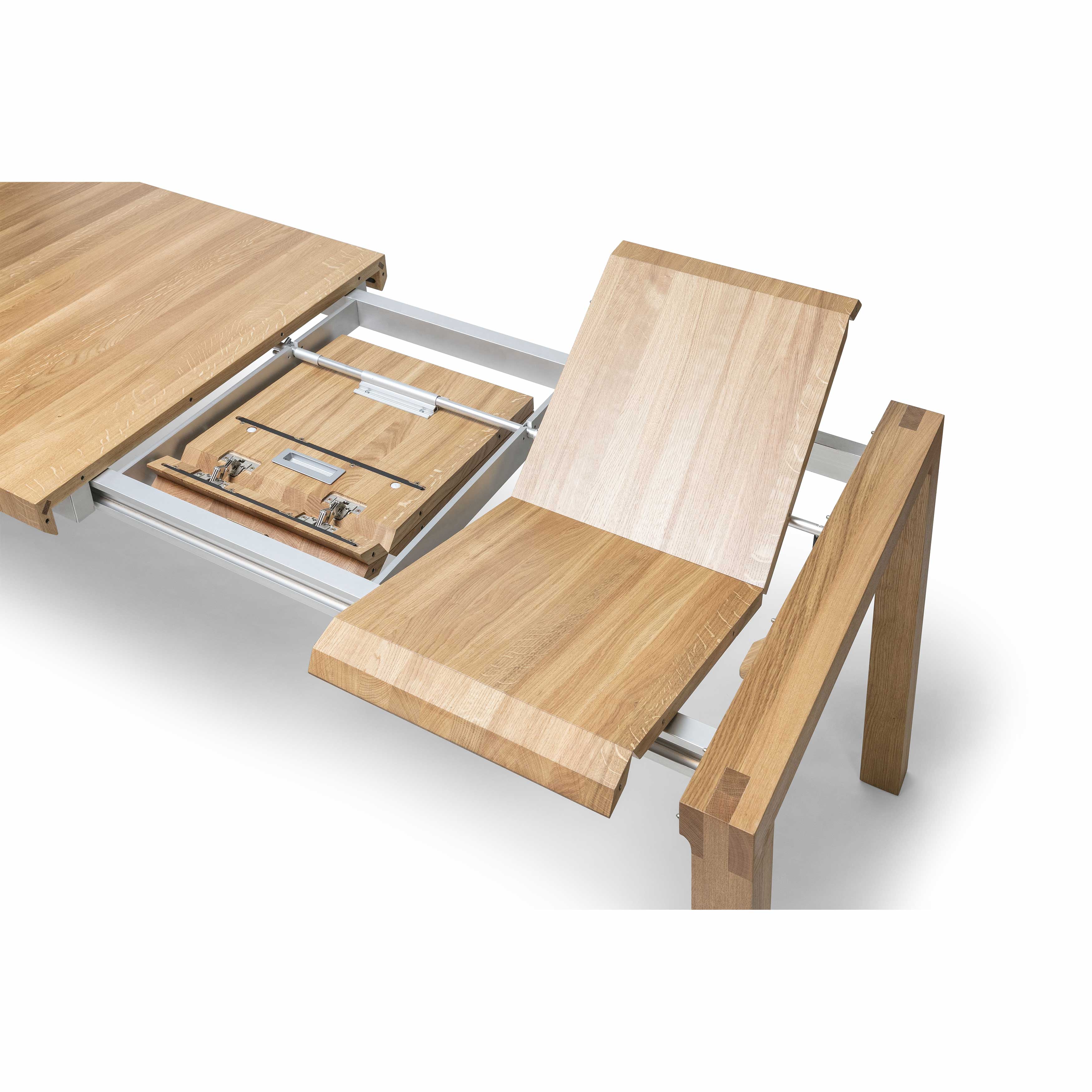 Close-up of the Table Chop by TON: a solid wood table with a partially open extension mechanism. It features a foldable leaf insert stored under the tabletop, supported by a metal frame, highlighting its craftsmanship and natural wood grain texture.