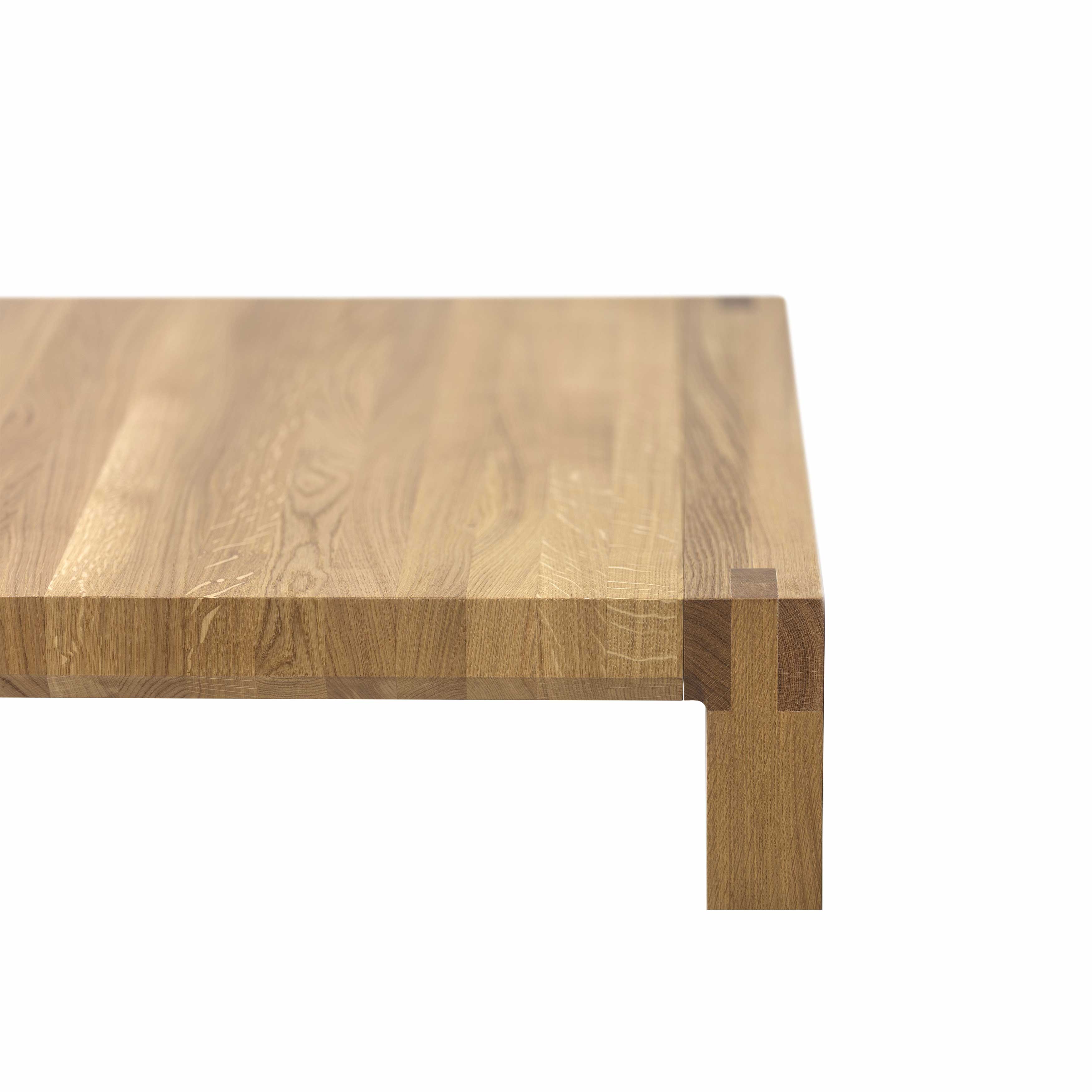 A close-up of the Table Chop by TON showcases quality craftsmanship with a smooth, light-brown solid wood surface and visible grain patterns. The sharply cut edge emphasizes its minimalist, modern design.