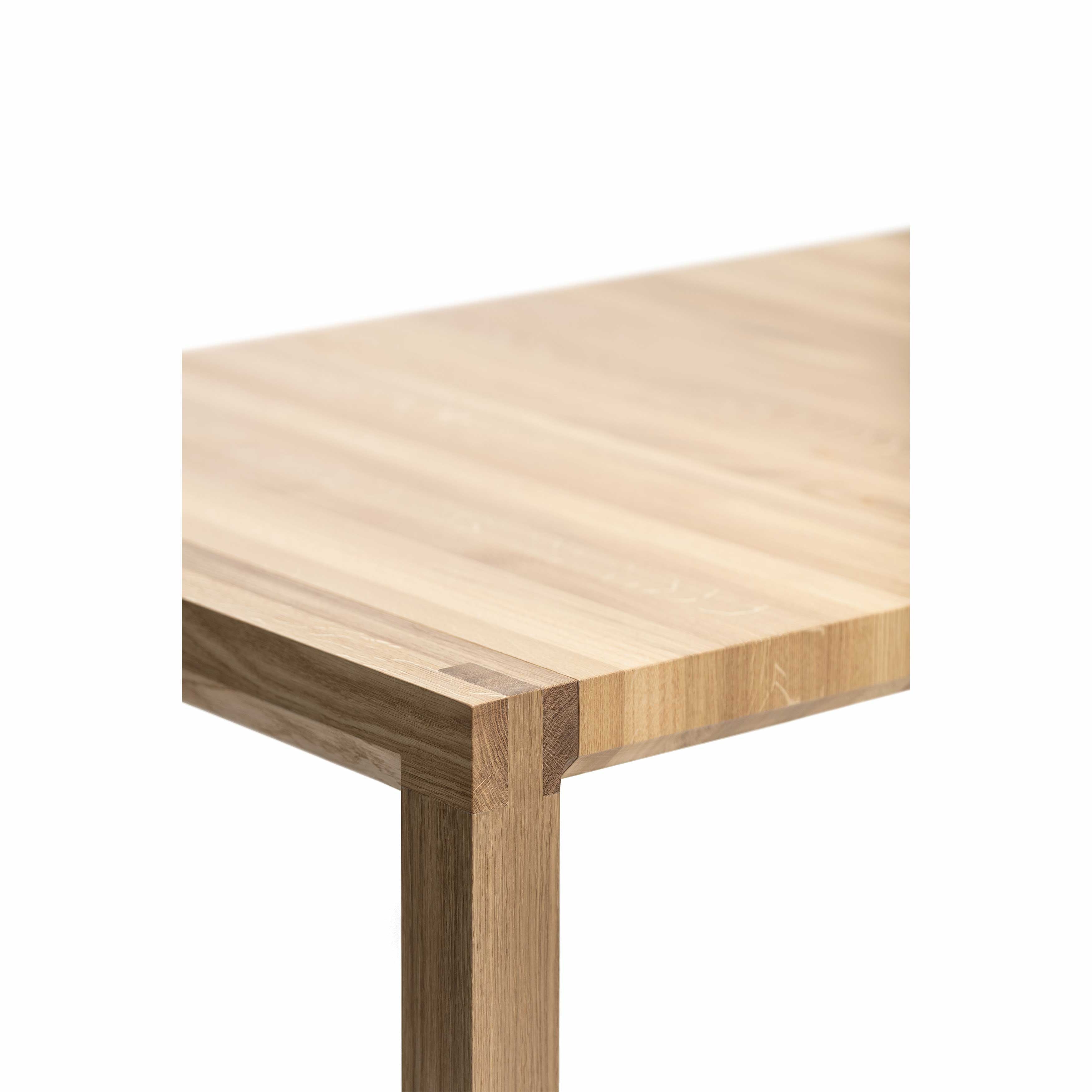 Close-up of a Table Chop by TON, featuring a solid wood corner with a smooth, light brown finish and visible grain. This minimalist design exhibits quality craftsmanship against a plain white backdrop.