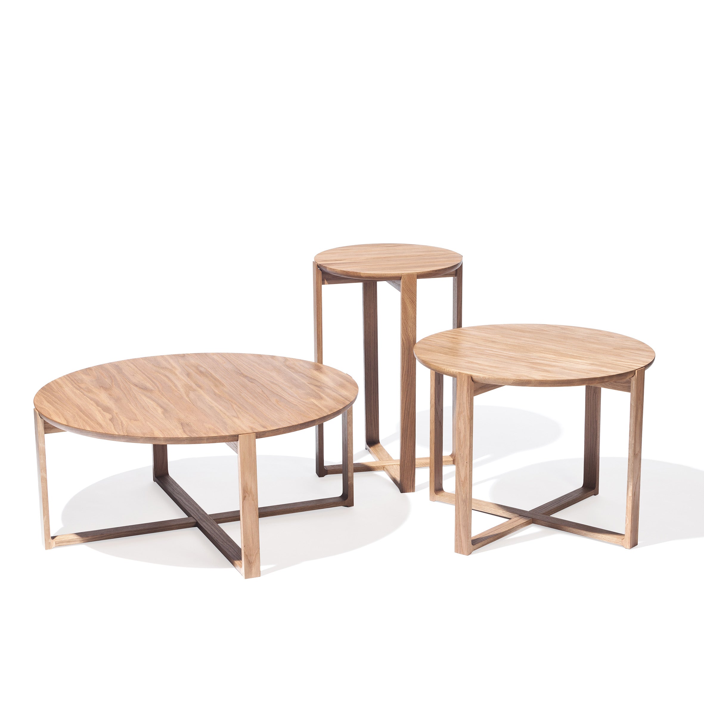 The Delta Coffee Table by TON features three wooden tables with sleek metal frames that exude elegance. The largest is a low, round coffee table, and the other two vary in height with round tops, all in a minimalist modern design on a white background.