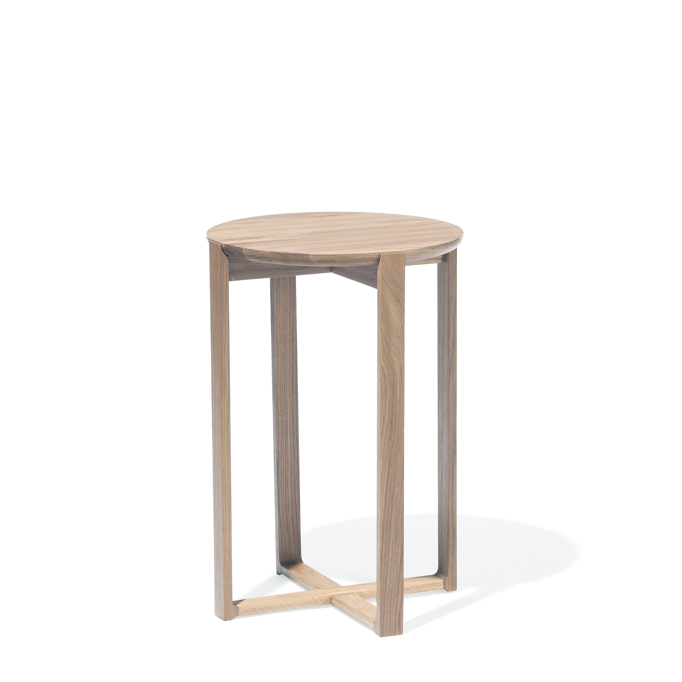 The Delta Coffee Table by TON is an elegant and versatile round side table, featuring a smooth top and open geometric base. Crafted from oak wood with a light natural finish, it casts a soft shadow on the white background.