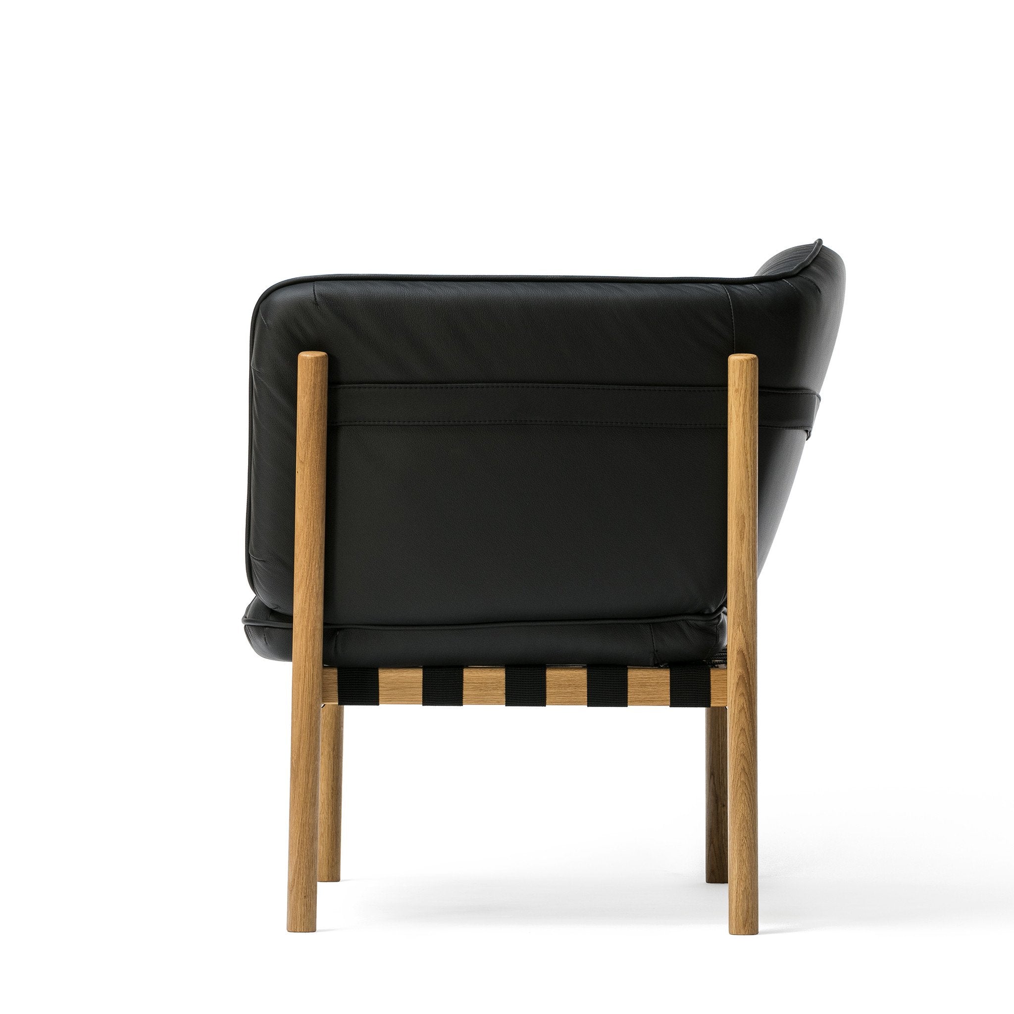 The Dowel Lounge Chair by TON is a black leather armchair with comfortable upholstery on a sleek cushion, supported by a wooden frame with a light finish, showcased against a plain white background.