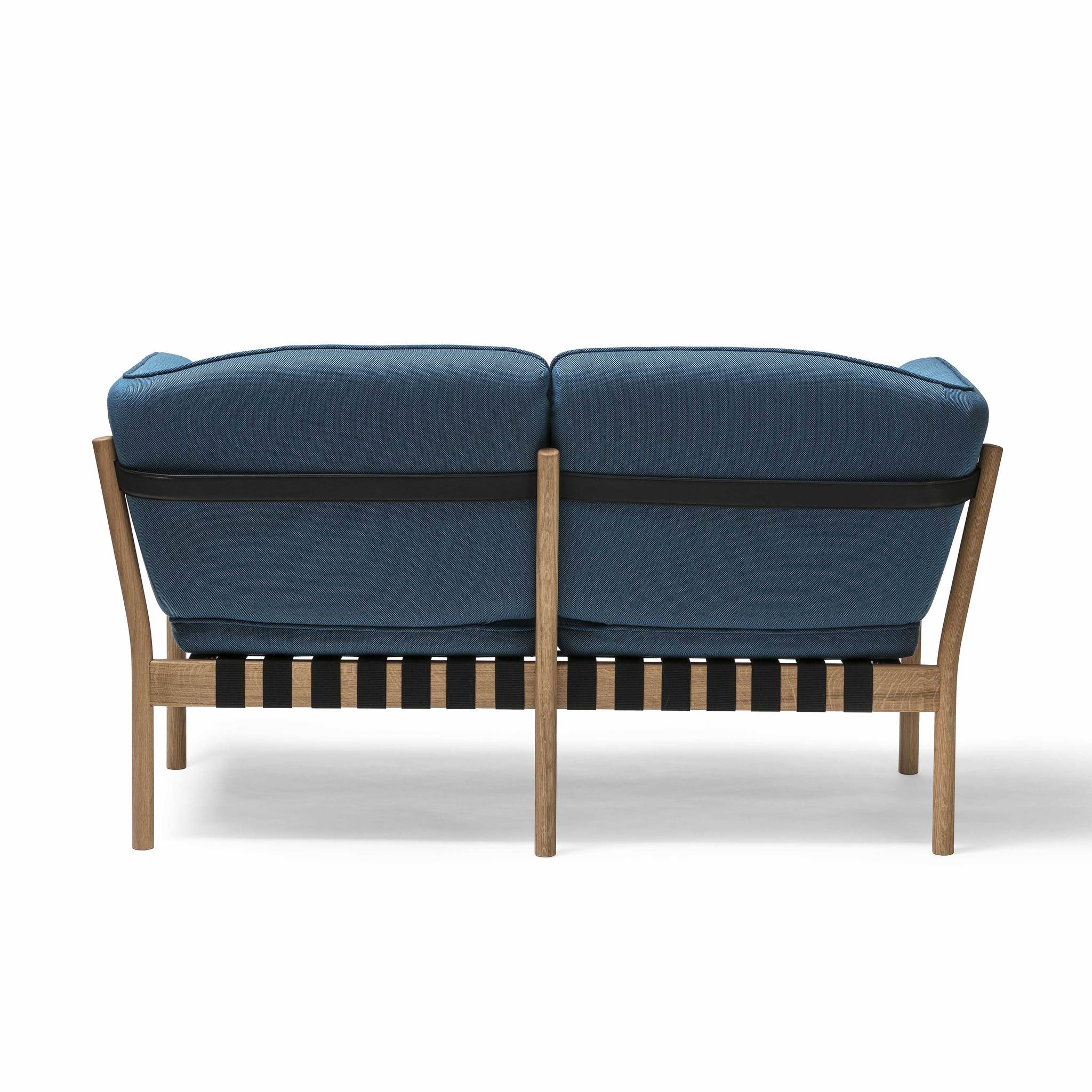 A rear view of the Dowel Two-Seater by TON reveals its modern design with a wooden frame and slatted backrest. This loveseat features deep blue cushioning, blending contemporary style with natural wood texture for comfortable living room seating.