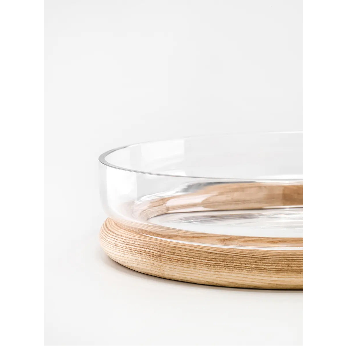 The Hoop Bowl by TON features a clear Czech crystal glass dish on a circular wooden base. The transparency of the dish contrasts with the warm bent wood, offering a minimalist and elegant look against a white backdrop—ideal for any TON portfolio.