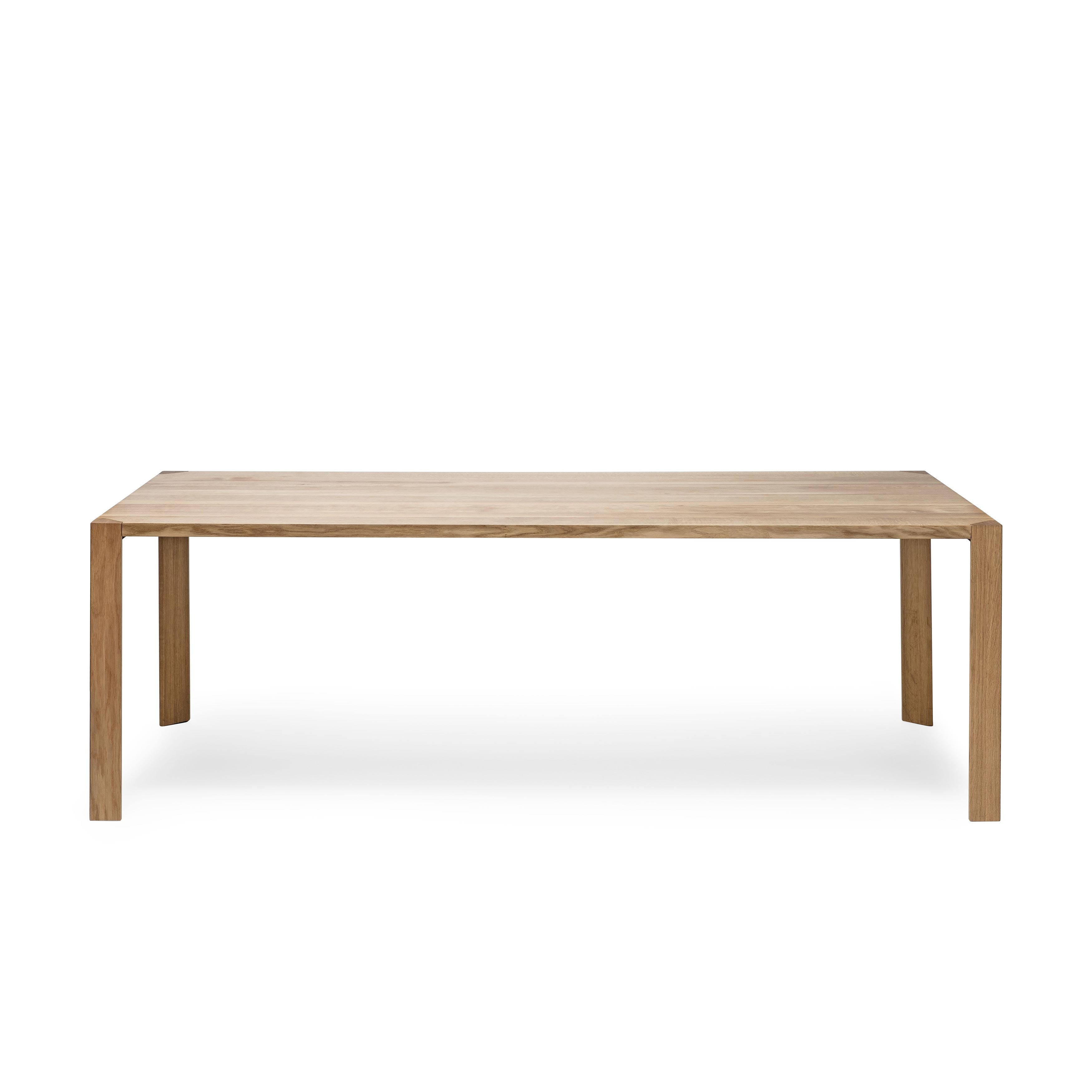 The Table Ink by TON is a minimalist rectangular wooden dining table with a thin tabletop and four square legs, featuring a natural wood finish perfect for modern dining spaces.