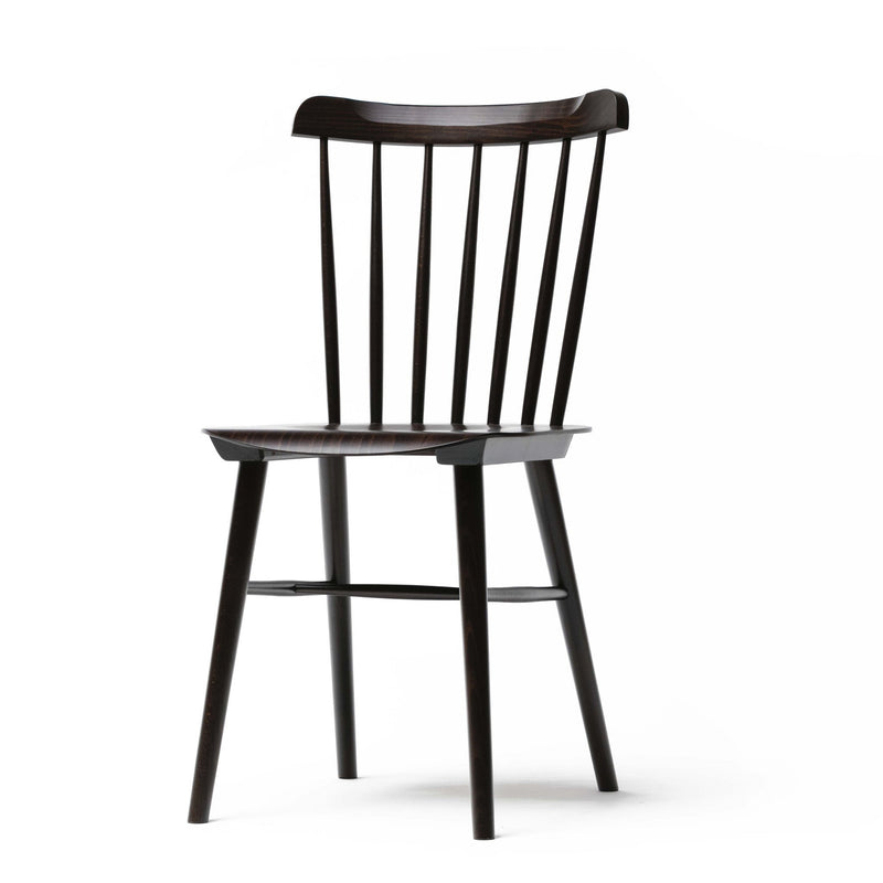 The Chair Ironica by TON is a sleek, minimalist wooden chair in a dark finish. It features a slightly curved backrest with vertical slats and four straight legs, crafted from beech wood, adding retro style to contemporary spaces.