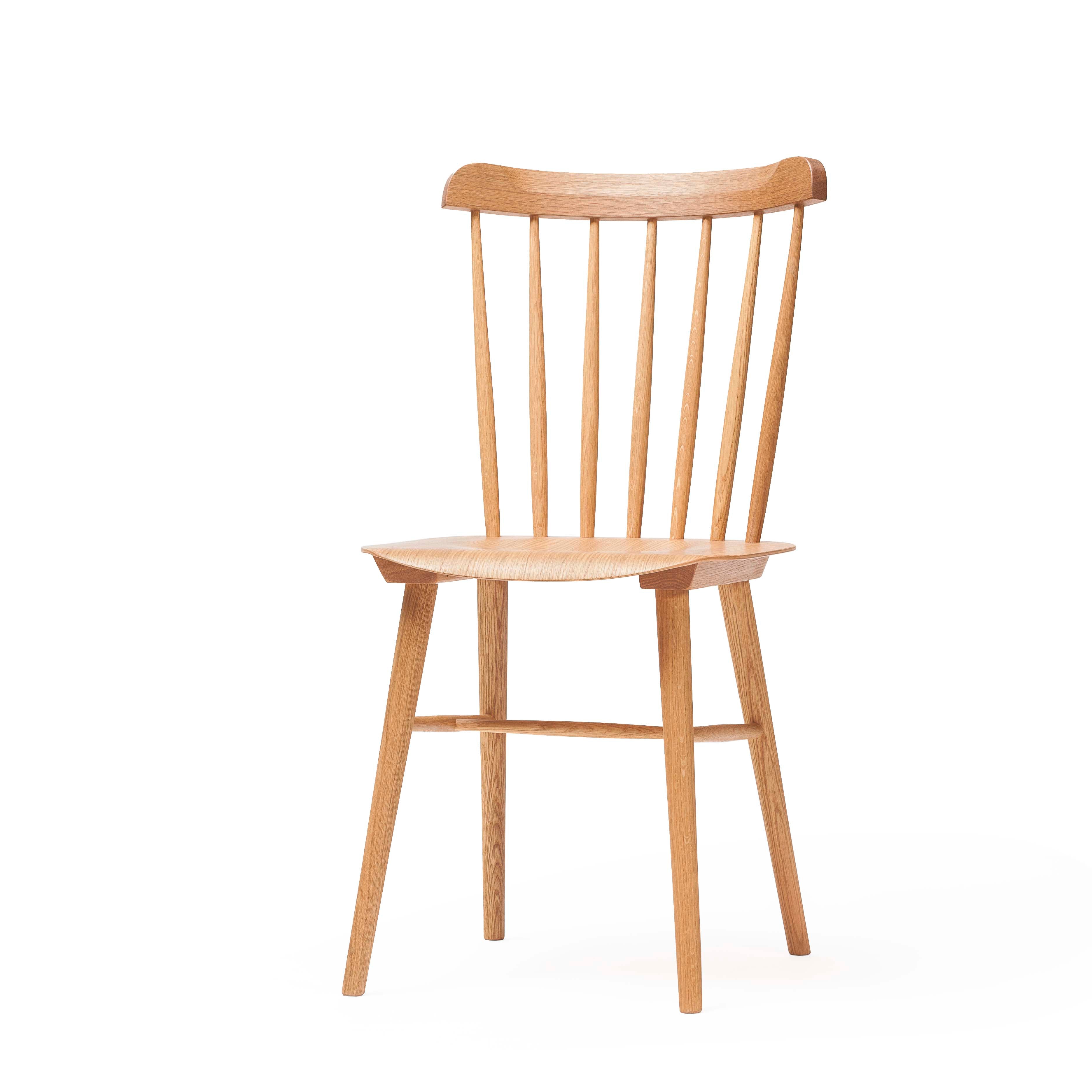 The Chair Ironica - Upholstered by TON boasts a curved backrest with vertical slats, flat seat, and four legs. Its light wood finish and simple yet elegant design capture a timeless retro style inspired by the classic Ironica chair.