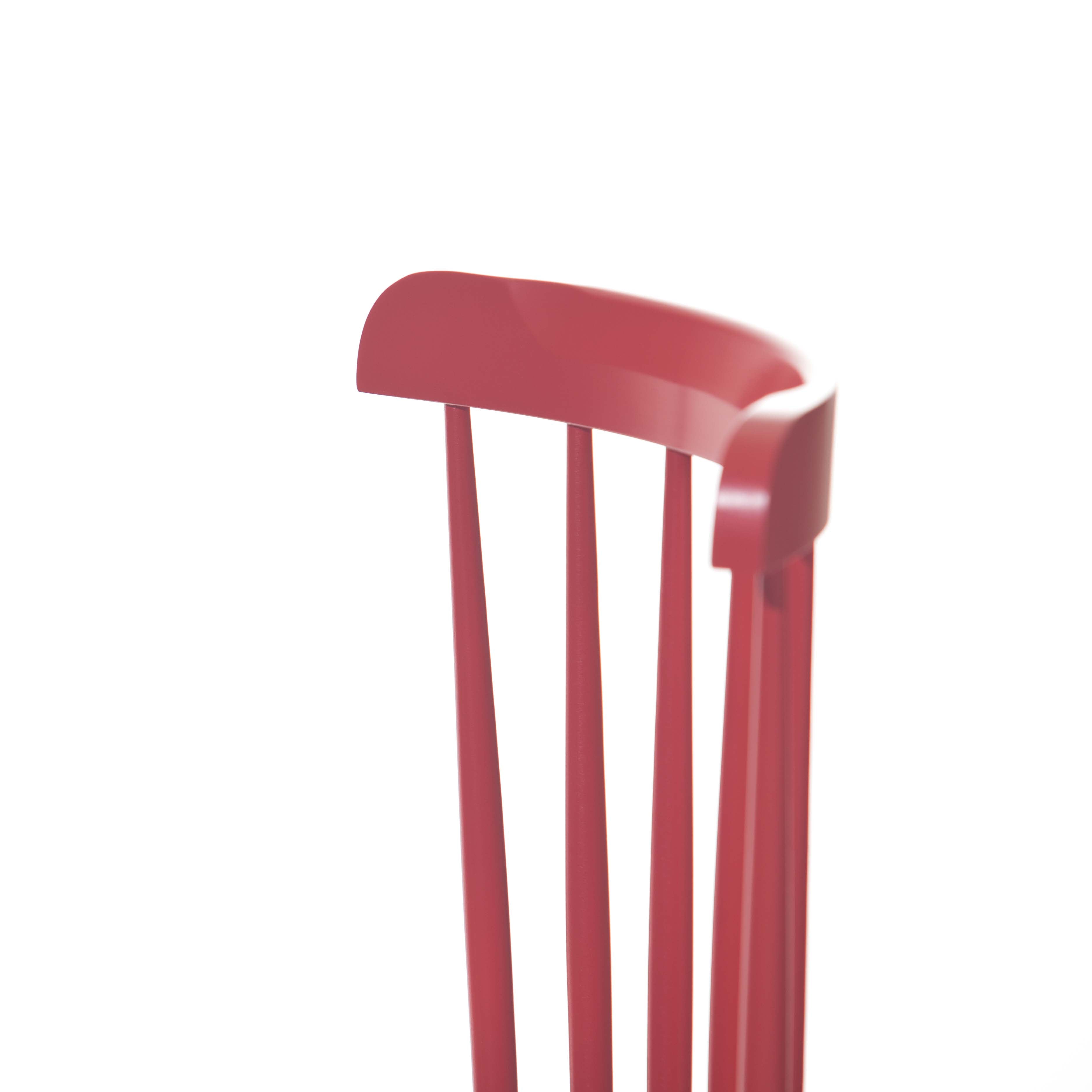 Close-up of the backrest of a red Chair Ironica - Upholstered by TON, featuring vertical slats. The retro-inspired design is minimalist, set against a plain white background.