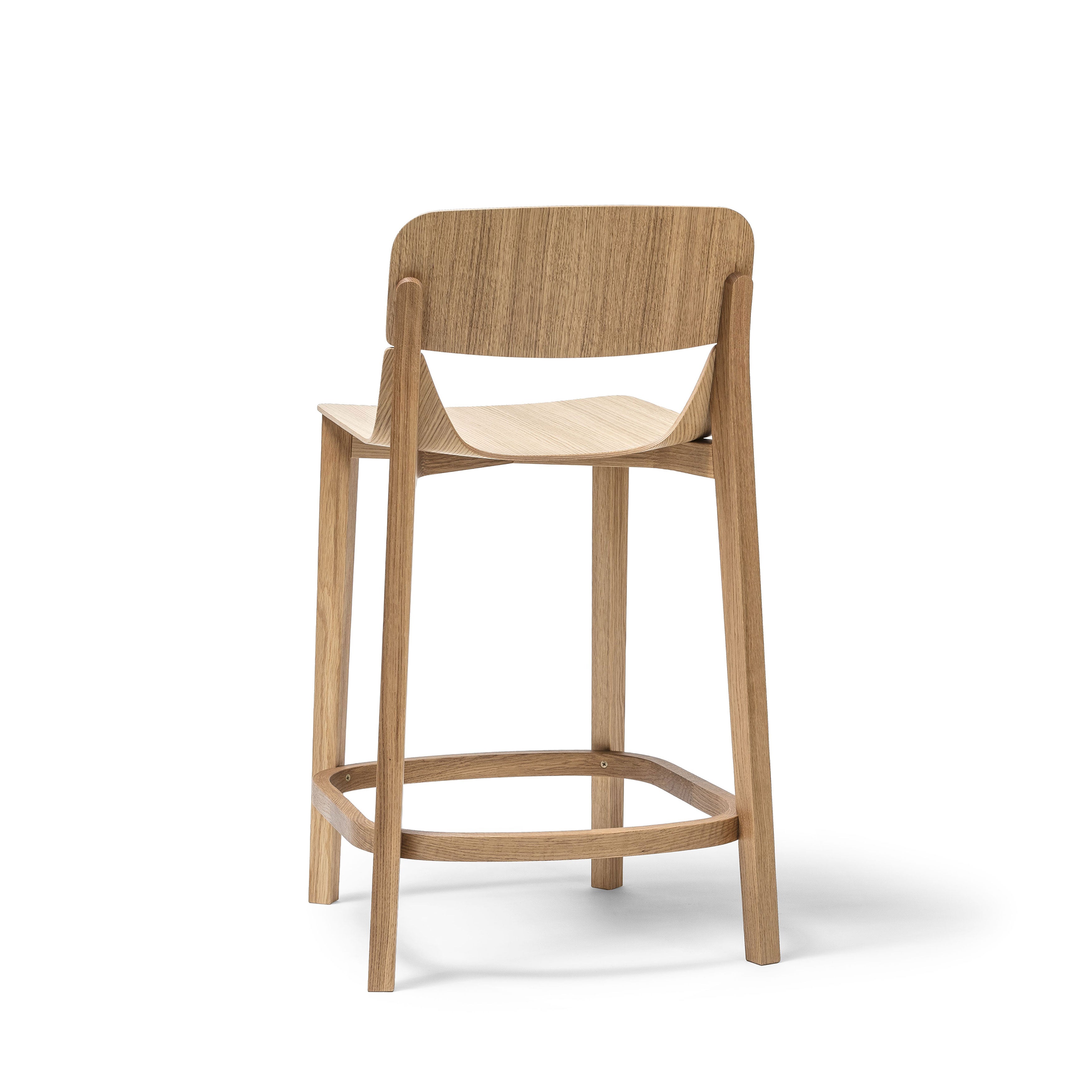 The TON Barstool Leaf with Backrest features an ergonomic design with a curved seat and back supported by four straight legs, connected by a horizontal footer for stability. Its minimalist style and natural wood finish make it essential for any stylish barstool collection.