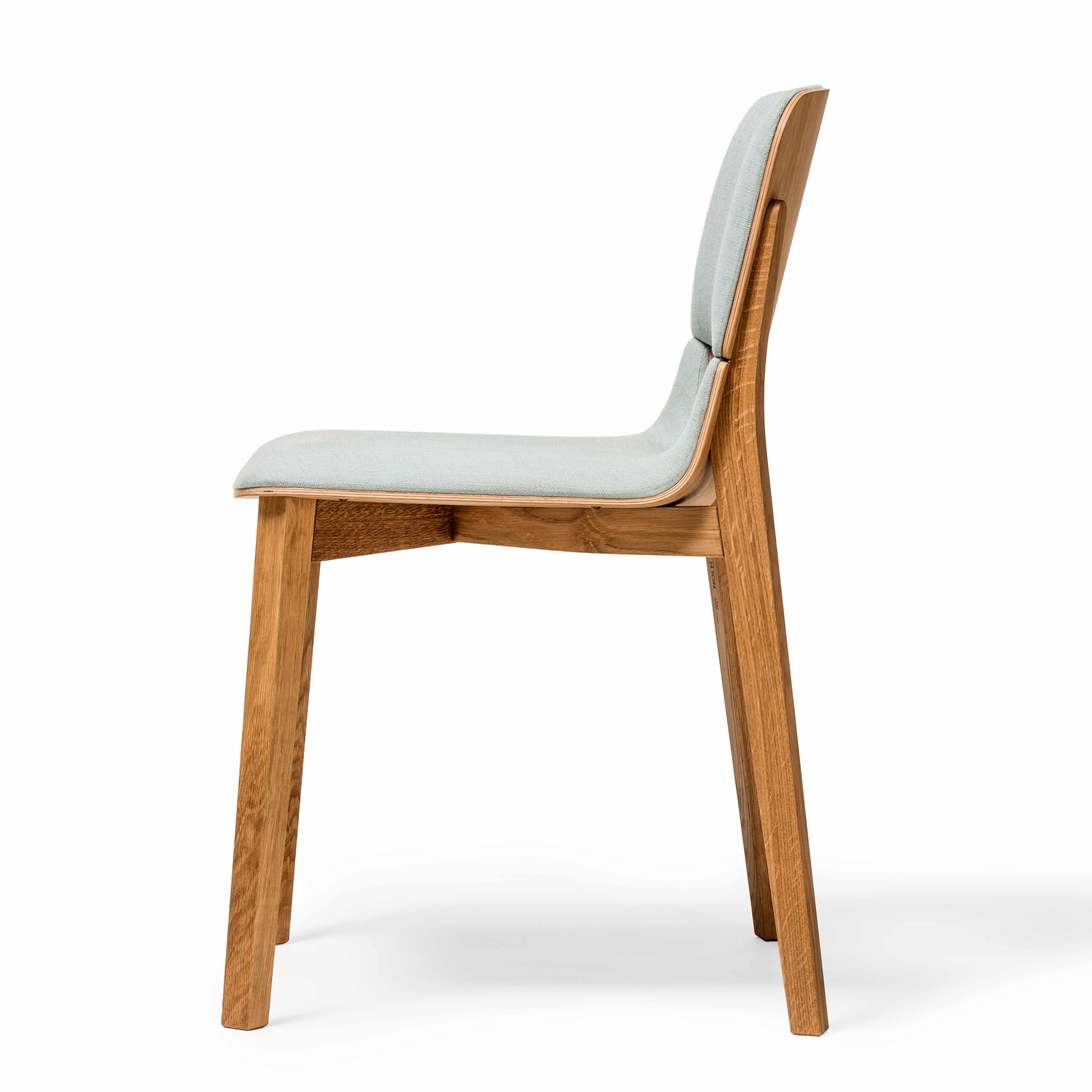 The Chair Leaf by TON, from the Leaf collection, boasts a modern minimalist design with ergonomic features. It includes a light gray cushioned seat and backrest, natural wood finish on sturdy legs—perfect for dining.