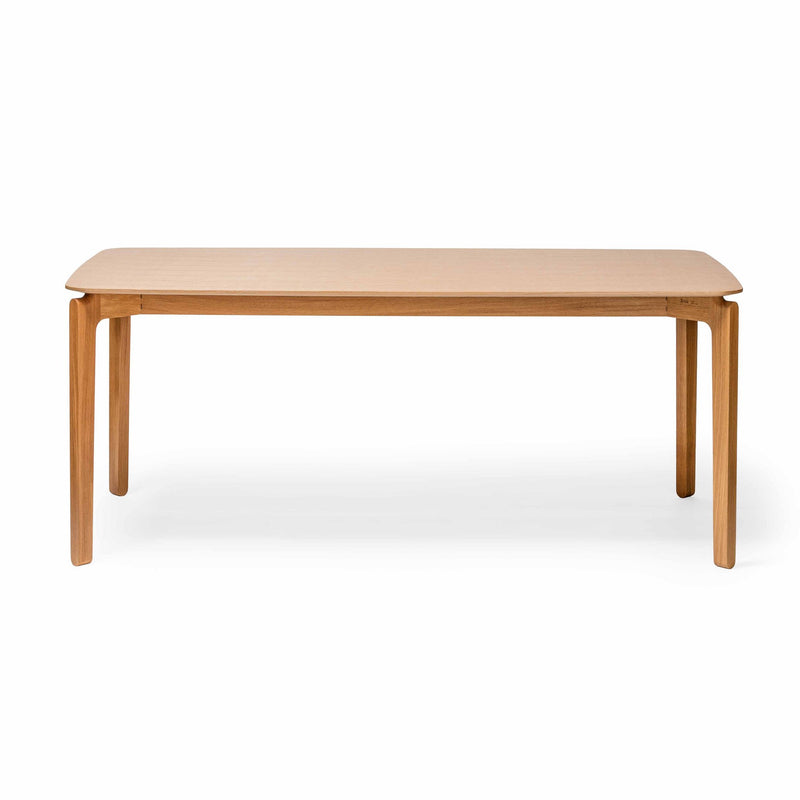 The Leaf Table by TON is a solid wood dining table featuring a smooth rectangular top, gently rounded corners, and four sturdy legs. Its natural finish provides an elegant look against a plain white background.