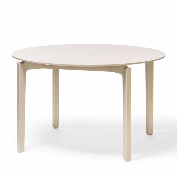 The TON Leaf Table Round is a minimalist solid wood piece with a smooth light beige surface and slender, slightly angled legs. Its clean, modern design exudes subtle elegance against a plain white background.