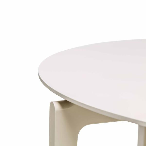 Close-up of the minimalist white Leaf Table Round by TON, featuring smooth edges and sleek design. The image highlights where the tabletop meets the leg, showcasing its solid wood craftsmanship.