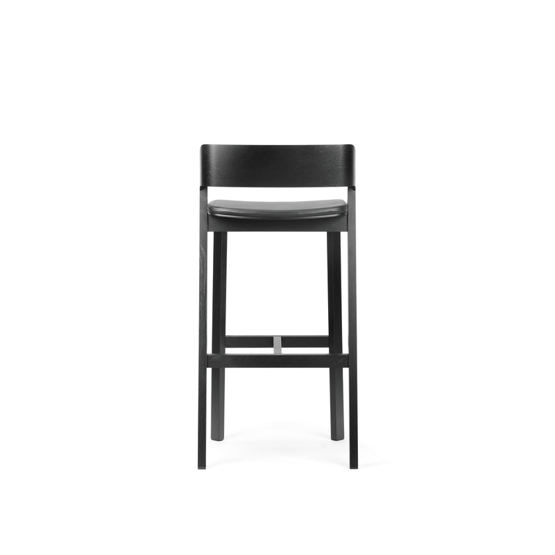 The Barstool Merano by TON is a sleek, modern piece made of solid wood, featuring a minimalist design with clean lines. It includes a backrest, footrest, and a smooth finish against a plain white background.