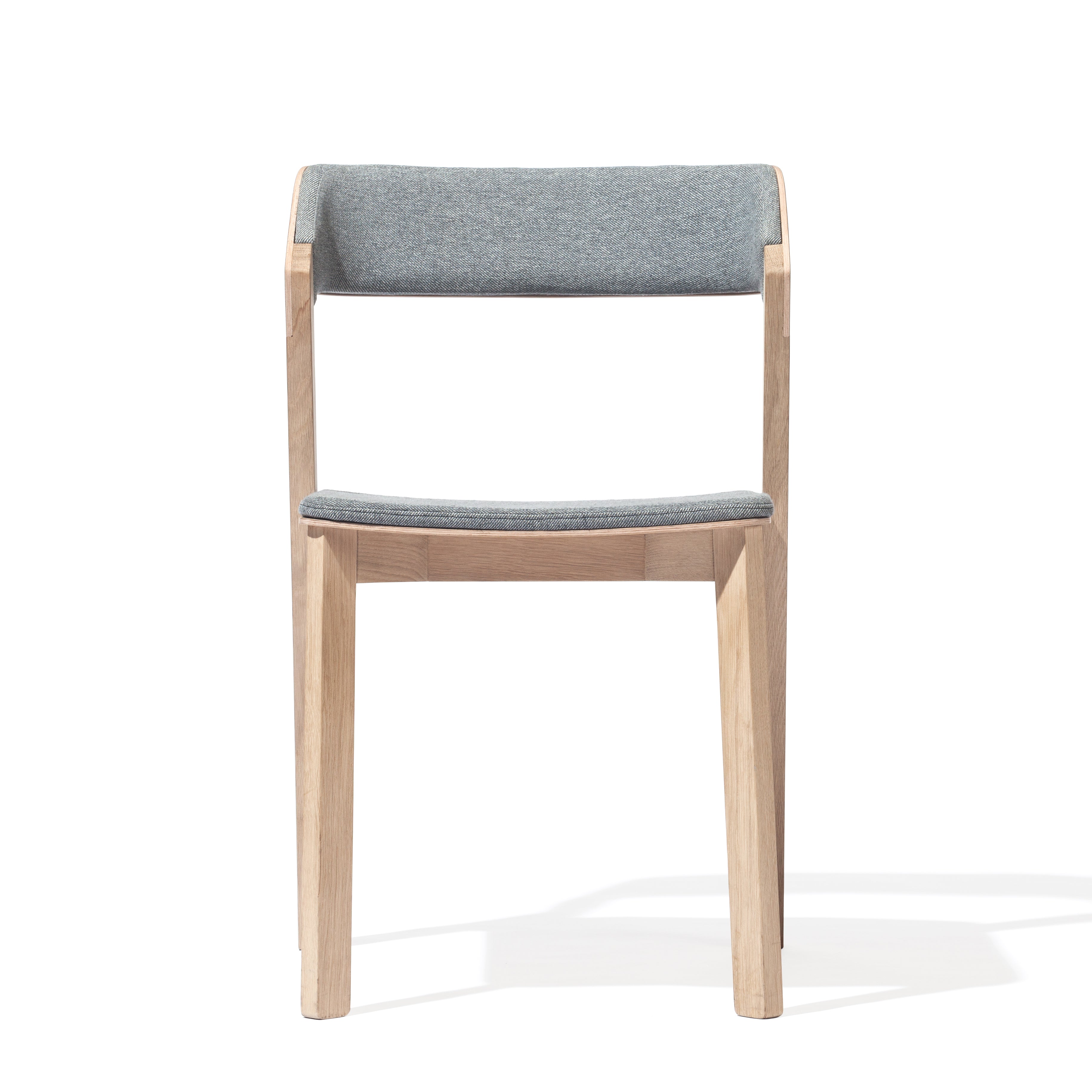 The Chair Merano Upholstered by TON boasts a minimalist design with solid wood construction, a light gray cushioned backrest and seat, straight legs for a modern look, and is set against a plain white background to highlight its sleek silhouette.