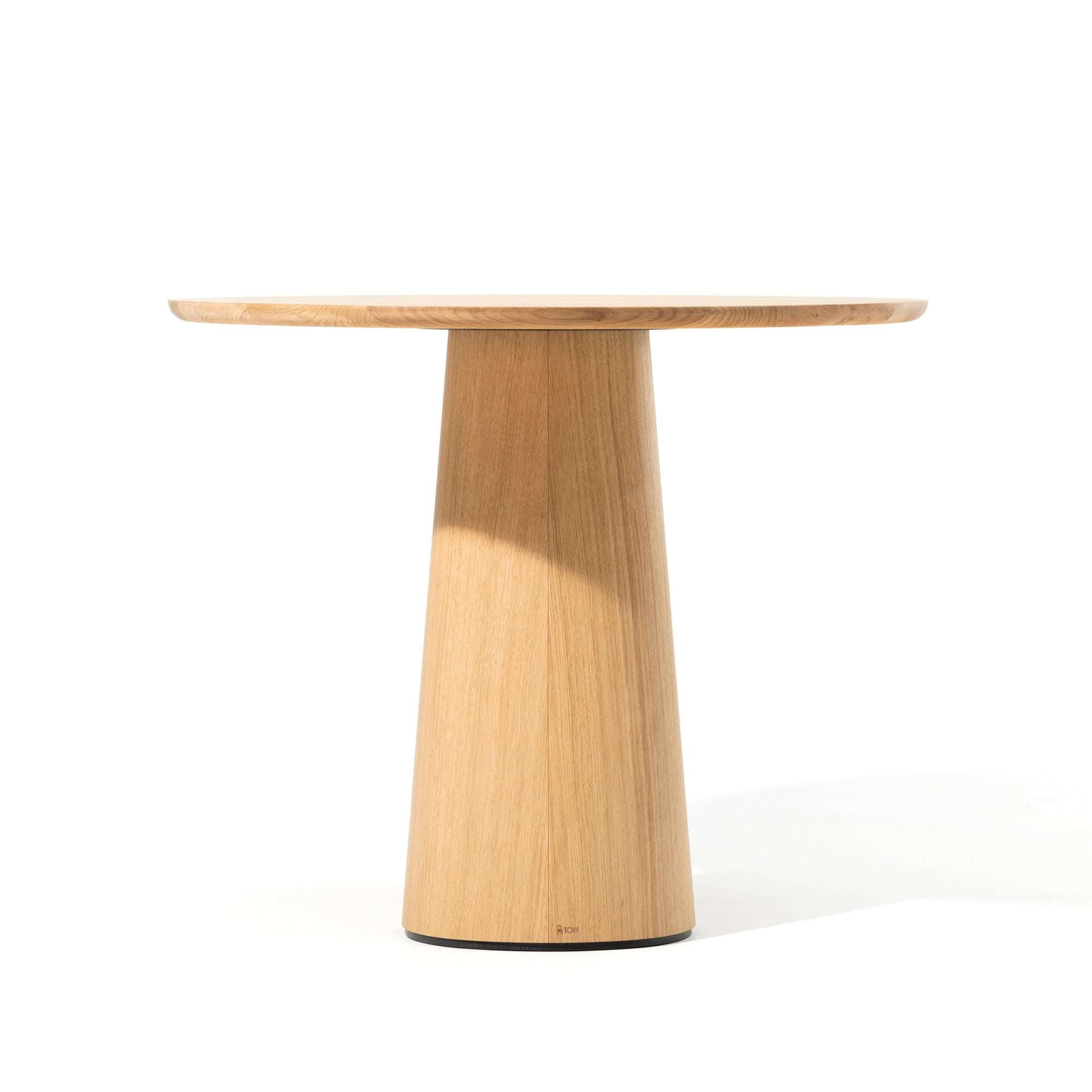 The P.O.V. Table 460 by TON is a minimalist round table with a light wood finish and a sleek conical pedestal base that embodies modern elegance. Its durable tabletop against a white background enhances its chic appeal.