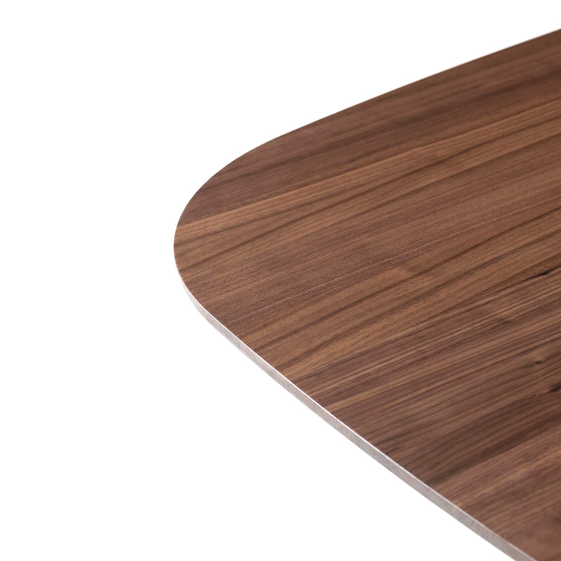 Close-up of the corner of a P.O.V. Table 466 by TON, made from solid wood with a rounded edge. The polished surface showcases beautiful wood grain patterns in shades of brown, highlighting its exquisite modular design.