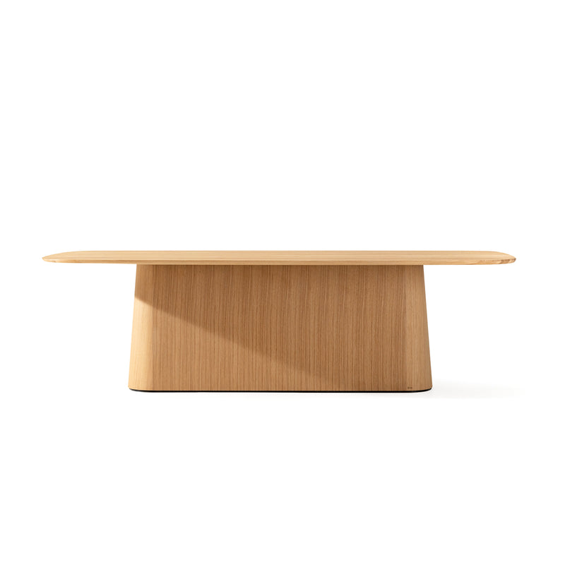 The P.O.V. Table 466 by TON features a rectangular top and wide, tapered base crafted from solid wood, with a smooth finish and minimalist design, standing out against a plain white background.