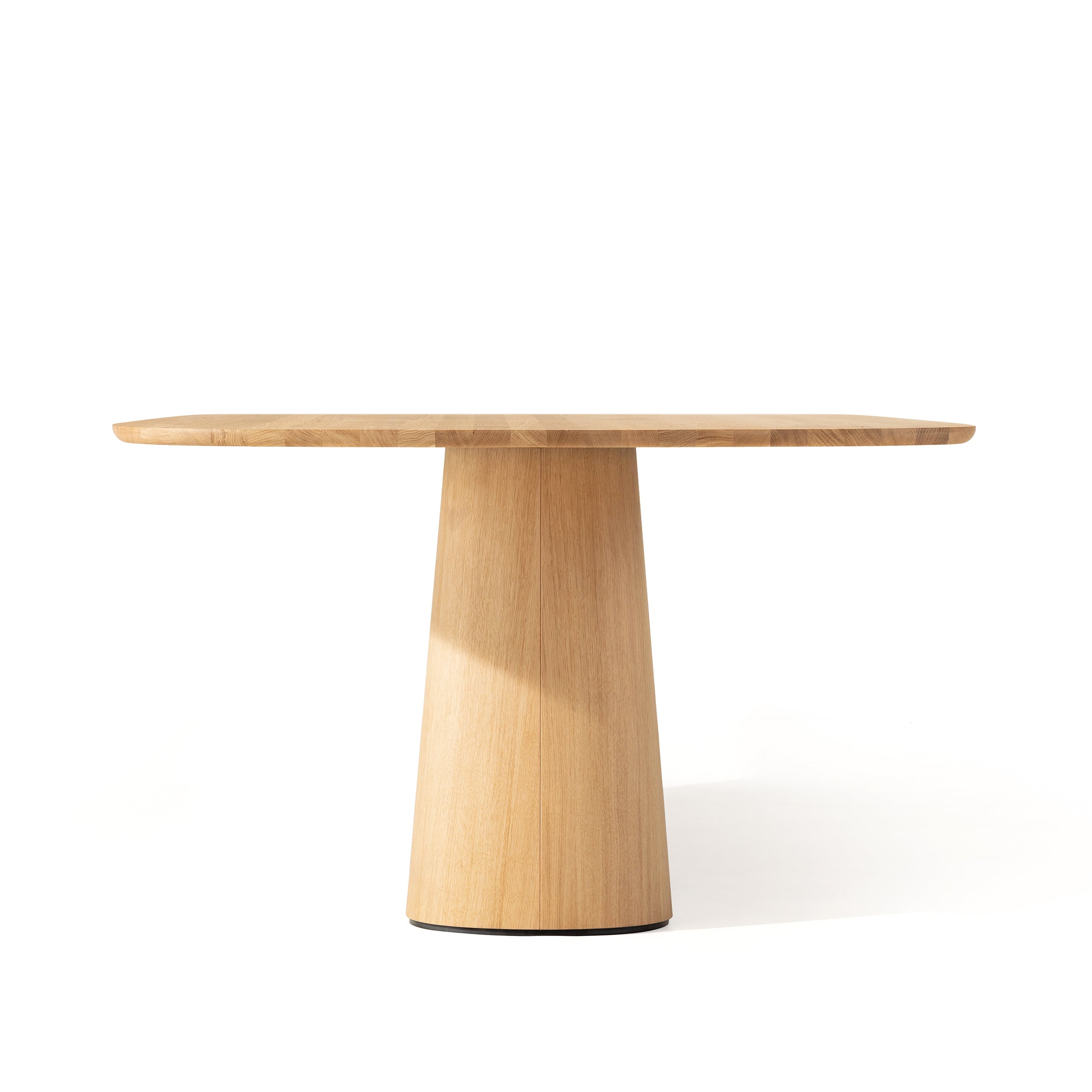 Discover the P.O.V. Table 466 by TON: a minimalist round wooden table with a tapered cylindrical base and light wood grain texture. Crafted from solid wood for elegance and durability, it features a timeless design on a white background.