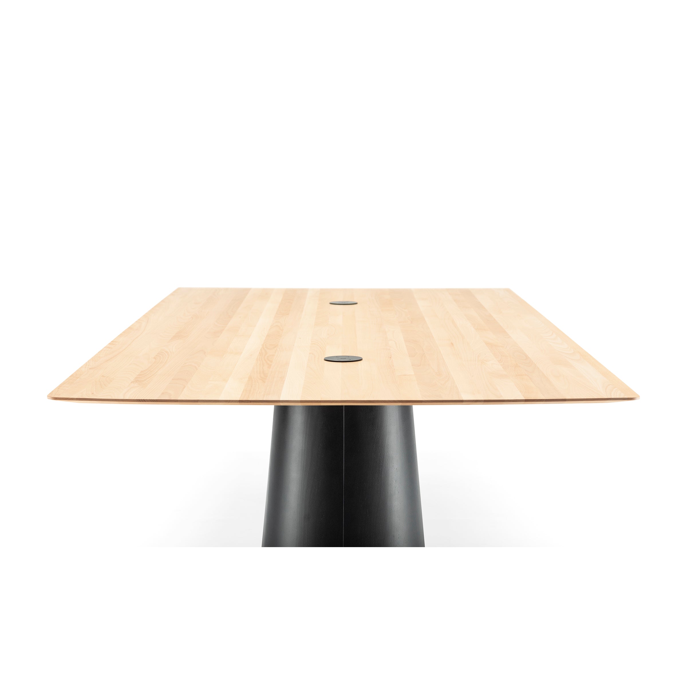 The photograph features the P.O.V. Table 467 by TON, a solid wood table with a light finish. It showcases a rectangular top and smooth black cylindrical base with two circular details near the center against a white background.