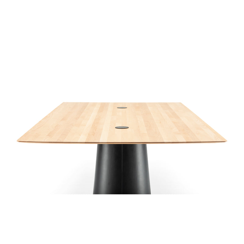 The photograph features the P.O.V. Table 467 by TON, a solid wood table with a light finish. It showcases a rectangular top and smooth black cylindrical base with two circular details near the center against a white background.