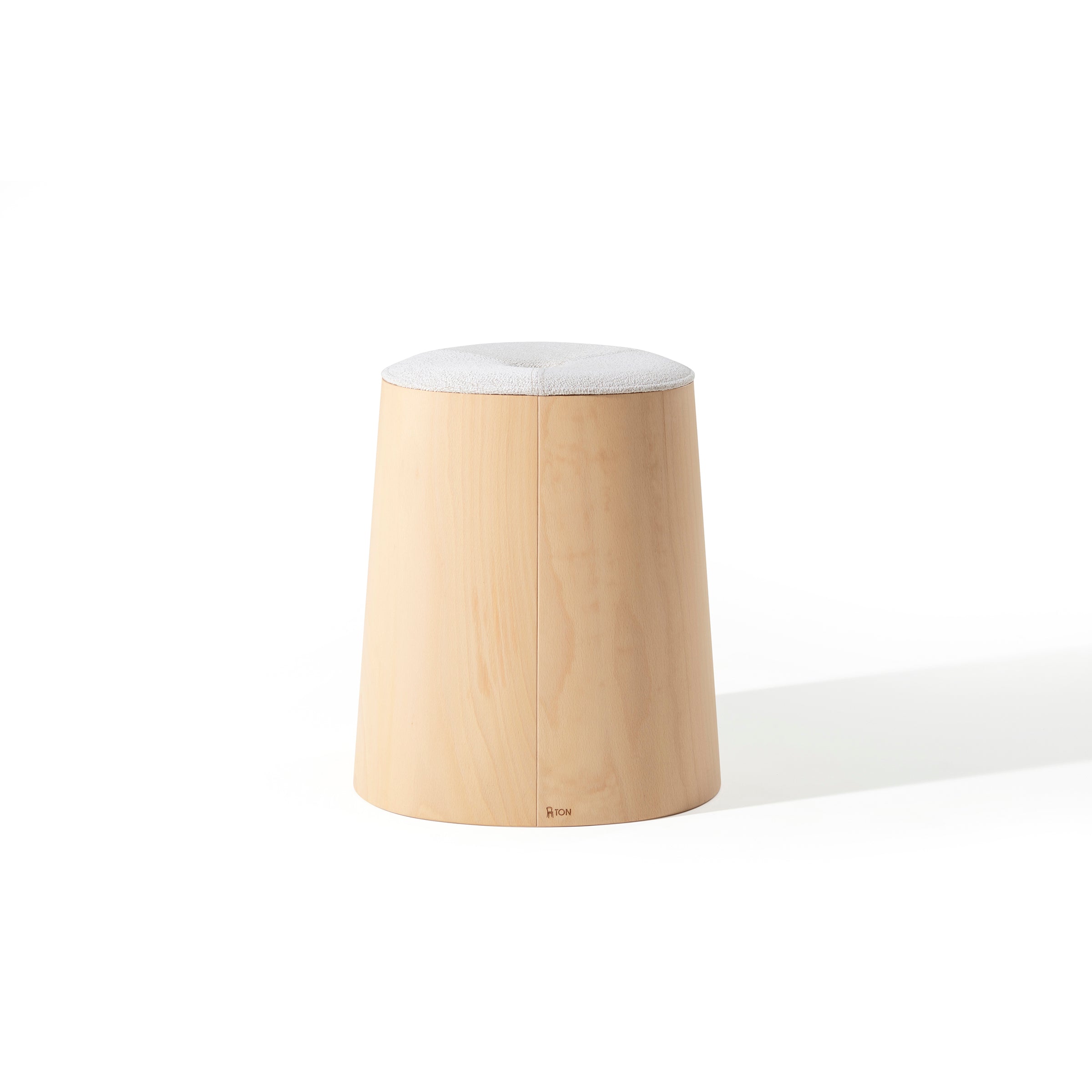 The P.O.V. Stool Upholstered by TON is a minimalist wooden stool with a light cylindrical structure, crafted from American walnut with a natural finish. It features a gray cushioned top and is ideal as a stackable dining stool, exuding simple elegance against a plain white background.