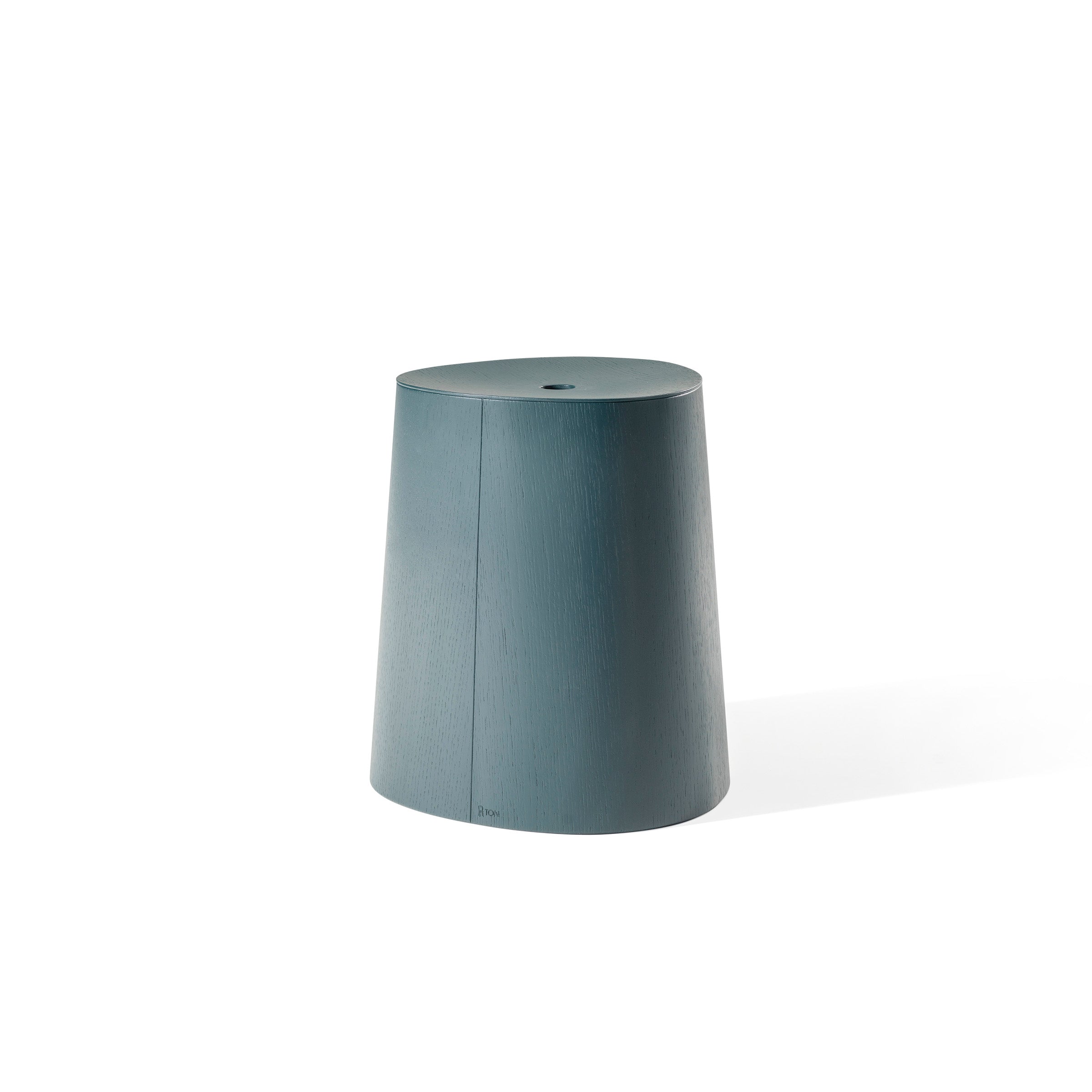 The P.O.V. Stool from TON is a teal, cylindrical stool with a slightly tapered design on a white background, featuring a smooth, flat top and subtle wood grain texture. Part of the P.O.V. collection, this stackable dining stool combines style with functionality.