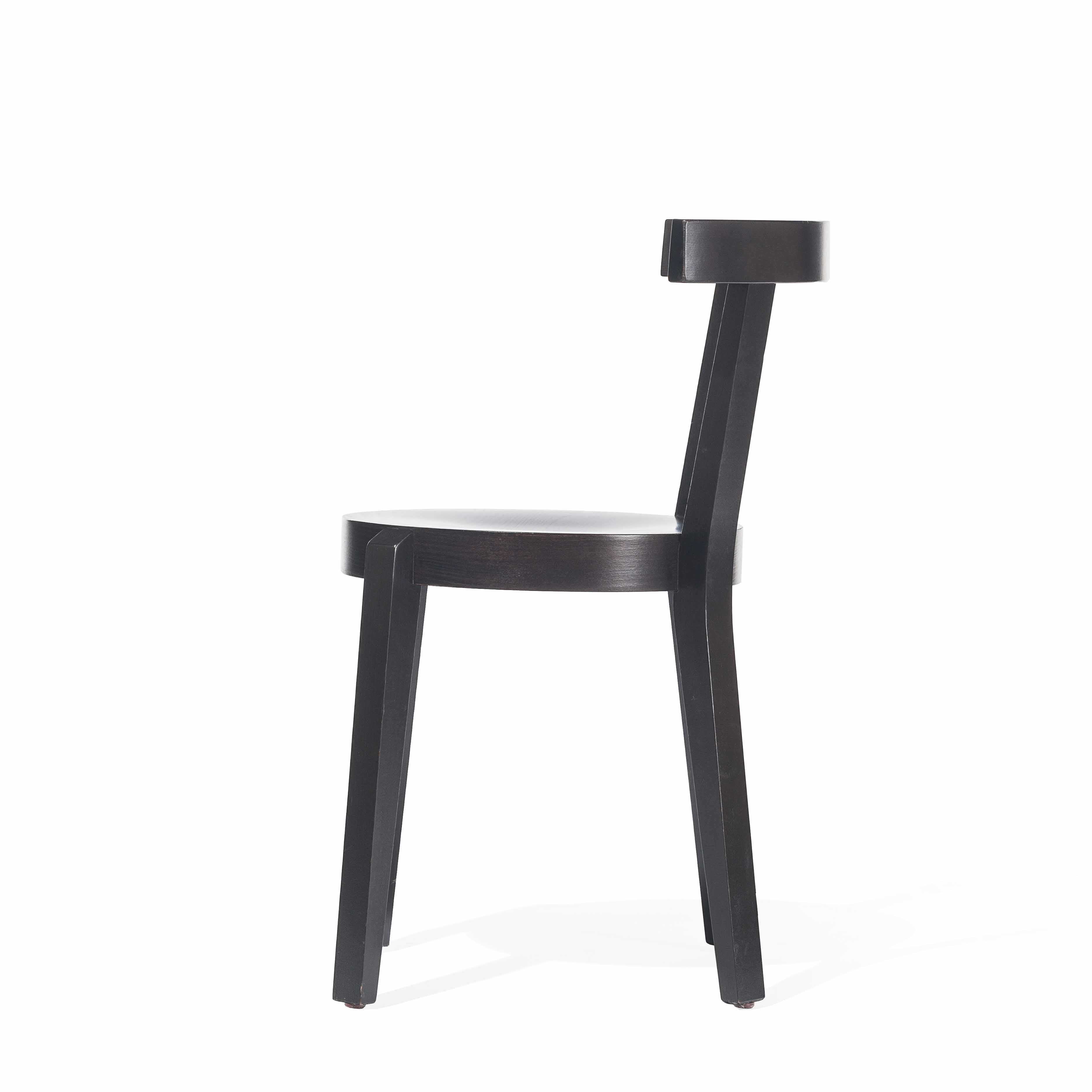 The Chair Punton by TON is a minimalist black wooden dining chair in a classic style. It features a circular seat, straight backrest, and four angled legs, embodying the elegance of bent furniture, and appears against a plain white background.