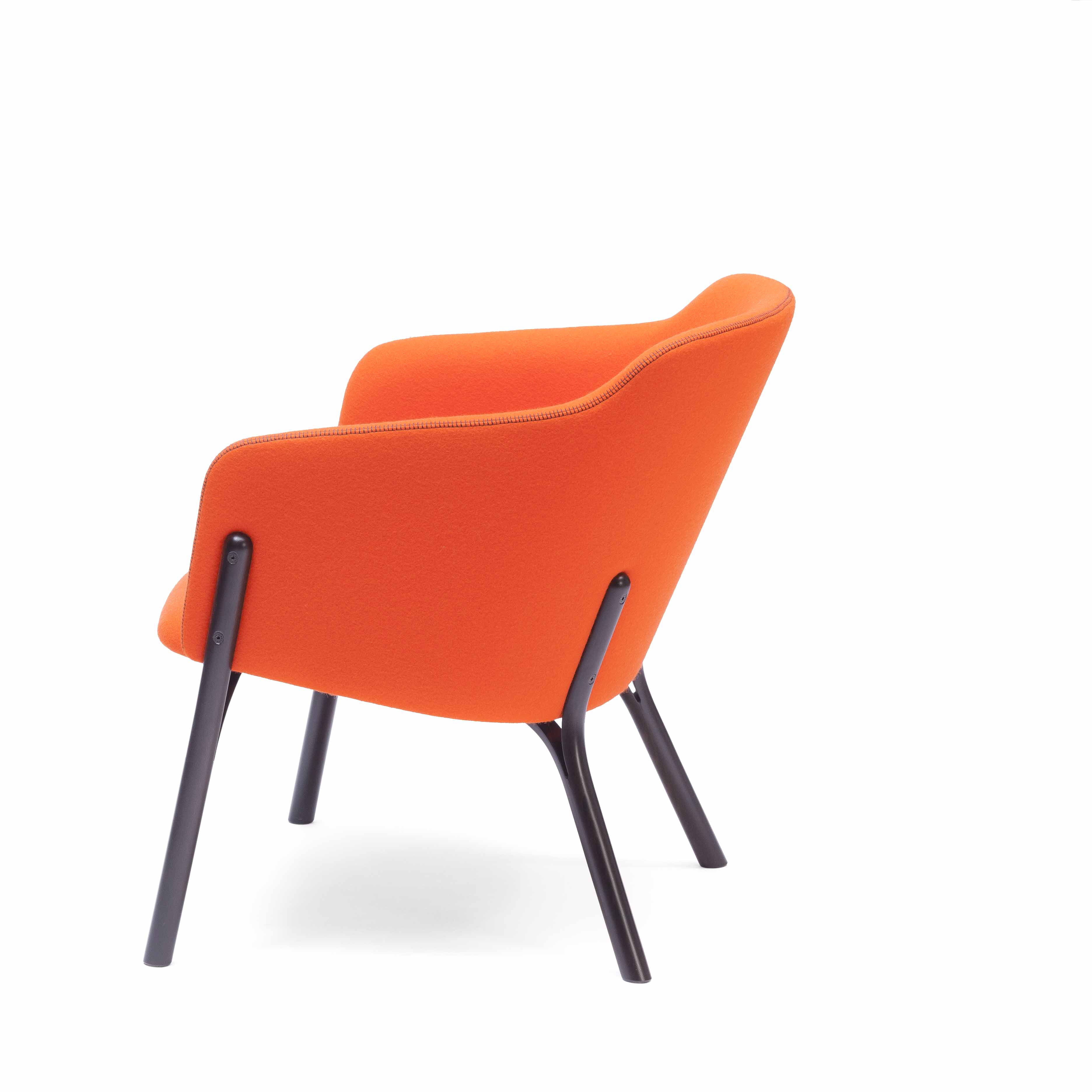 A contemporary orange Lounge Chair Split by TON features a curved backrest made from manually bent wood with sleek black metal legs, seen in a side profile against a white background.