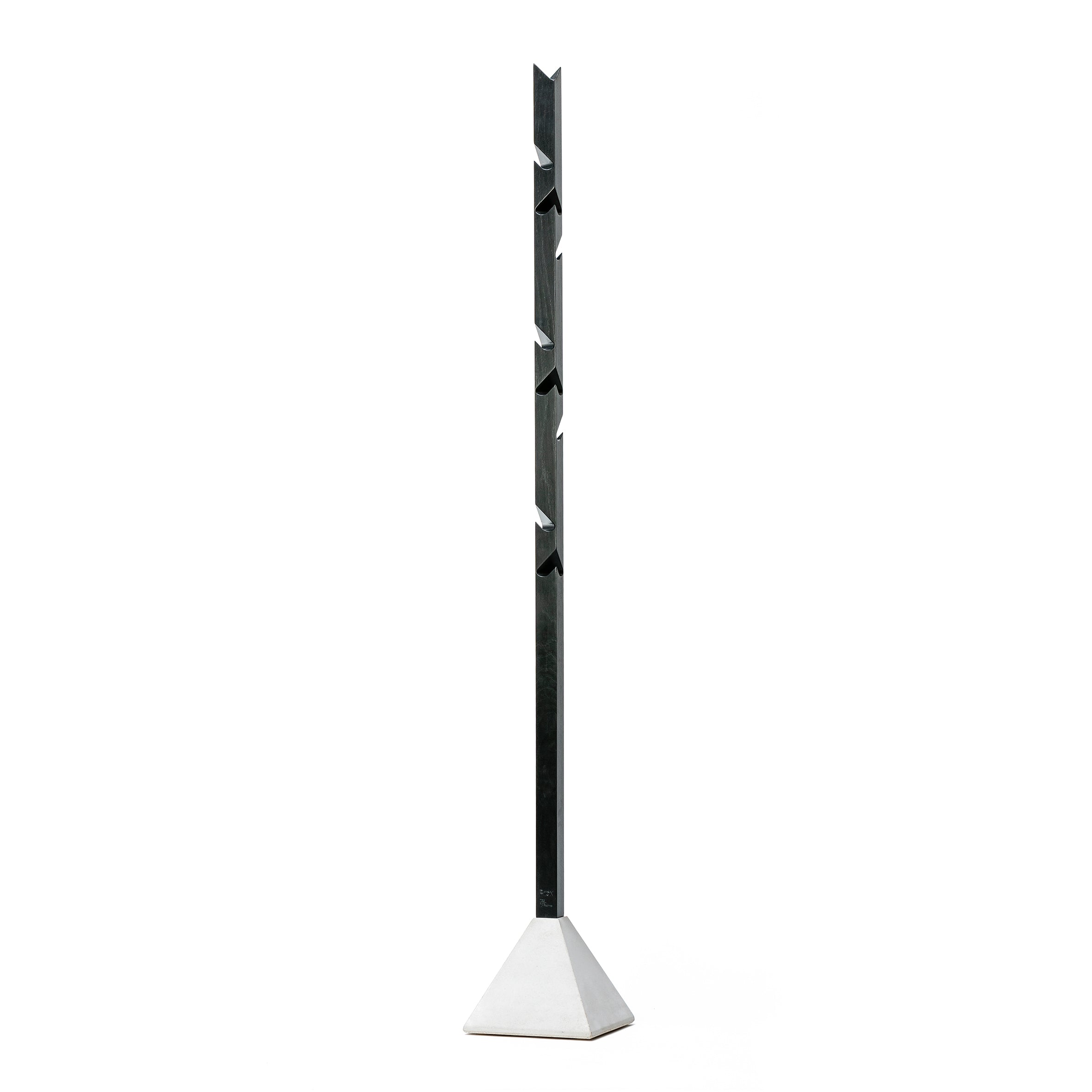 The Tee by TON is a modern, minimalist coat rack with an angular metal design that stands vertically on a sleek oak and concrete base, featuring evenly spaced hooks.