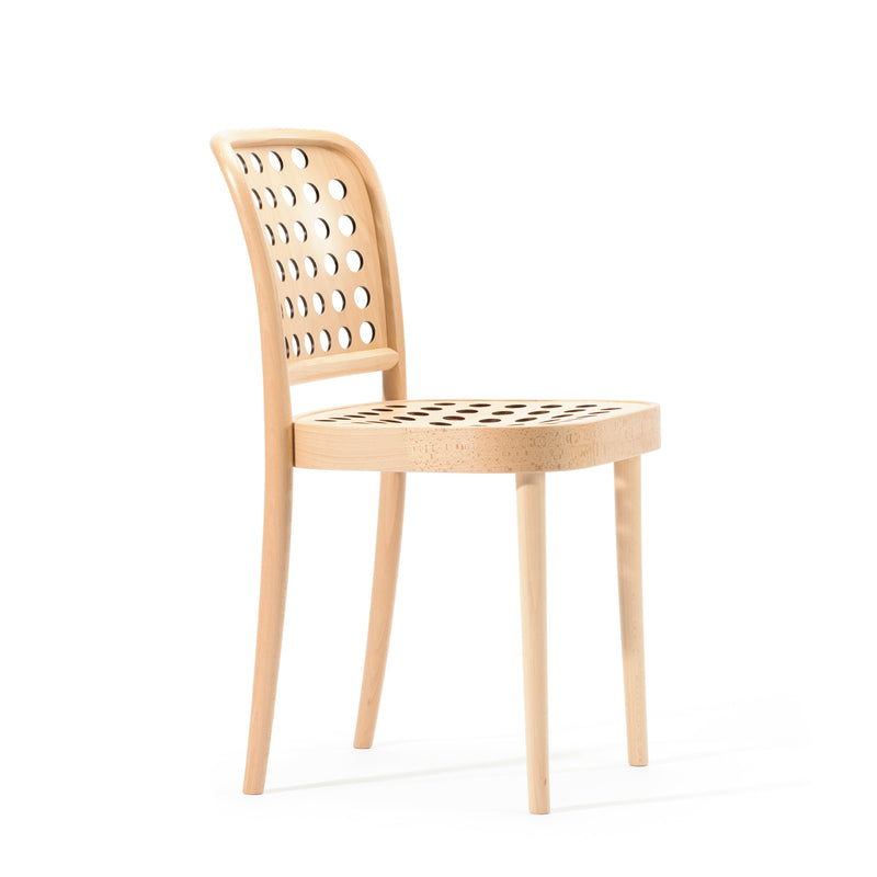 The Chair 822 by TON embodies Scandinavian minimalism with its curved backrest and drilled circular seat holes. Crafted using manual wood-bending technology, it features four legs and a minimalist design against a white background.